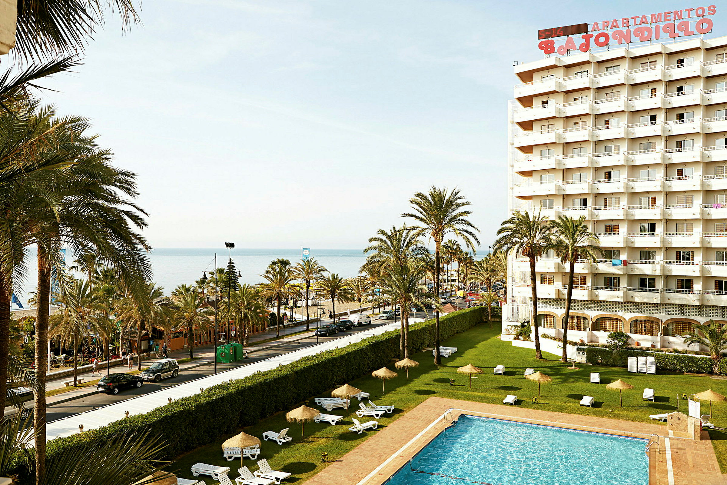 Bild av ett hotell med pool, palmer och utsikt över havet. (AI-genererad text)