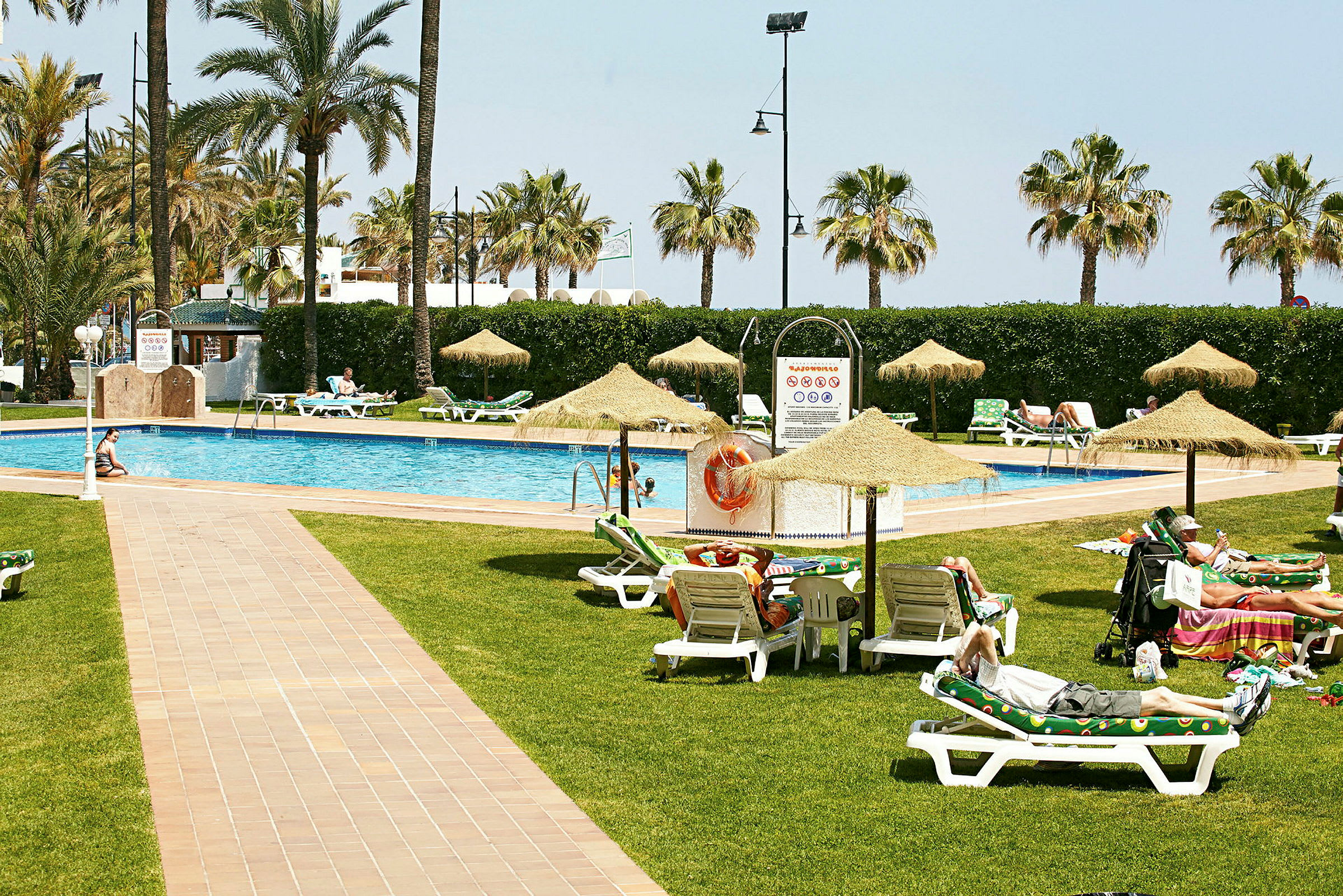 Hotellpool med solstolar och parasoller. (AI-genererad text)