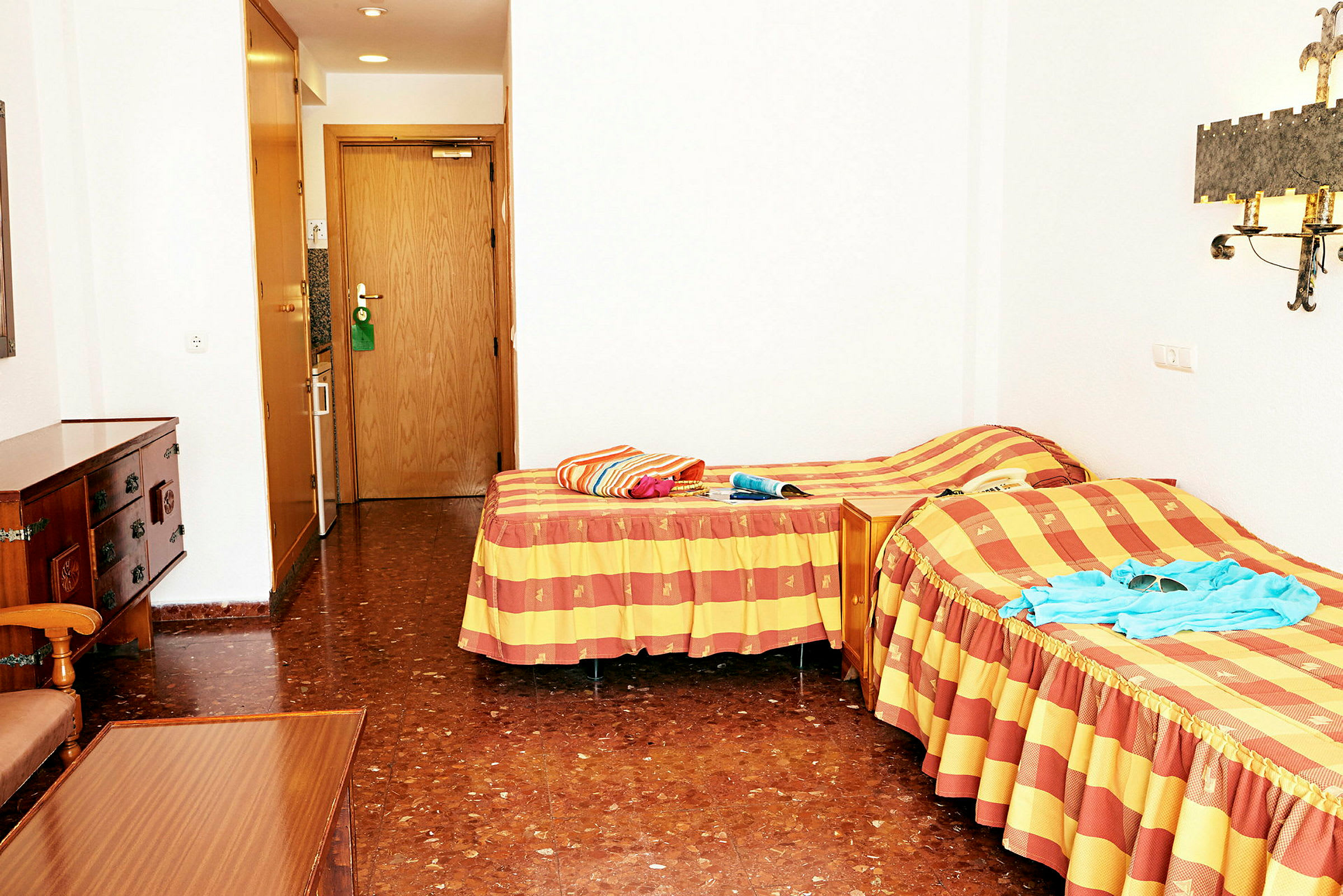 Ett hotellrum med två enkelsängar och en dörr till badrummet. (AI-genererad text)