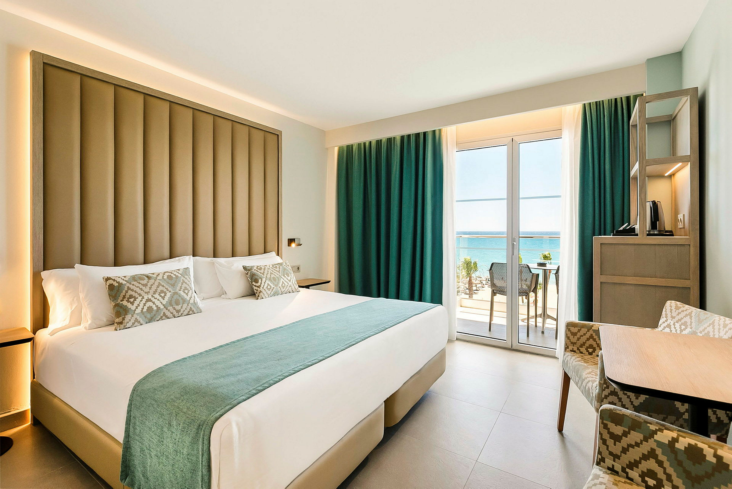 Hotellrum med stor säng samt balkong med havsutsikt. (AI-genererad text)
