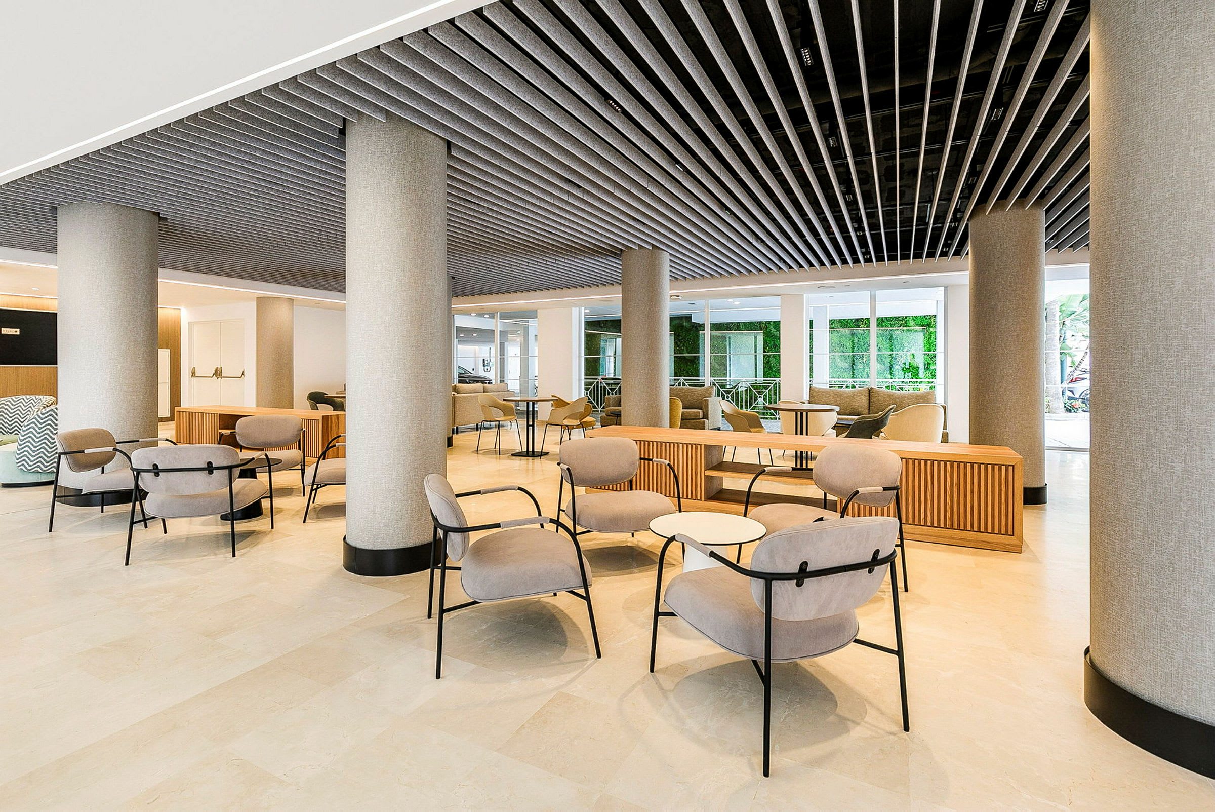 Ett hotelllobbyn med moderna möbler och pelare. (AI-genererad text)