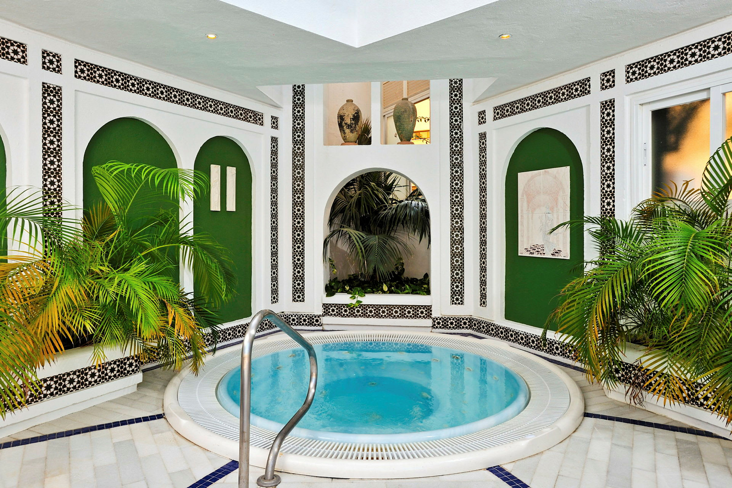 Interiör med jacuzzi, gröna växter och vit väggdekoration. (AI-genererad text)