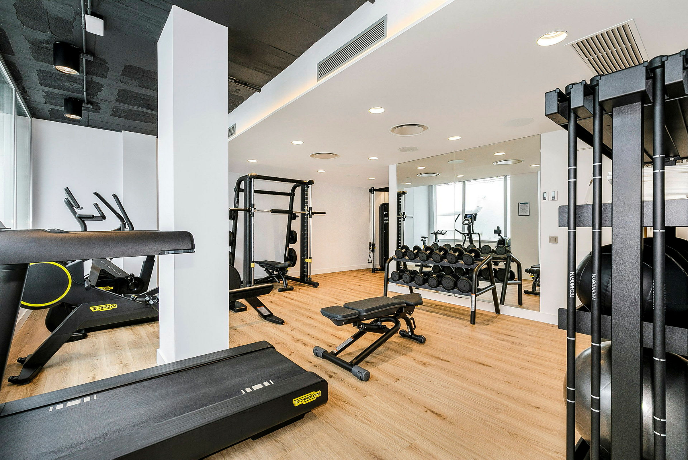 Ett modernt gym med träningsutrustning som löpband, vikter och maskiner. (AI-genererad text)