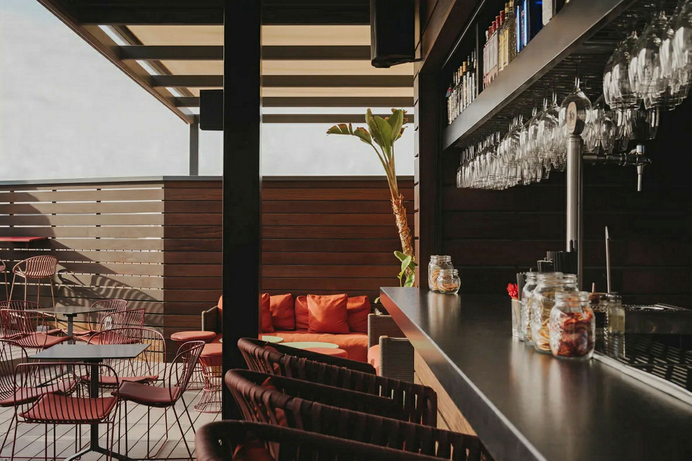 En modern bar med sittplatser och glas upphängda på väggen. (AI-genererad text)