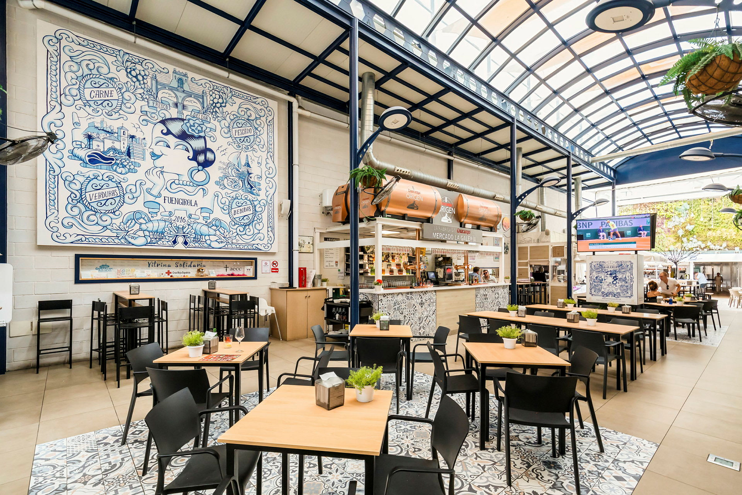 En ljus restaurang med sittplatser, ett kafédiskområde och väggdekorationer. (AI-genererad text)