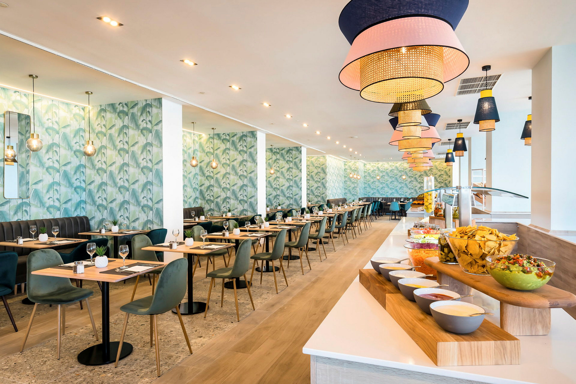 En modern restaurang med bord och stolar. Längs höger sida finns en buffé med olika rätter och tillbehör. (AI-genererad text)