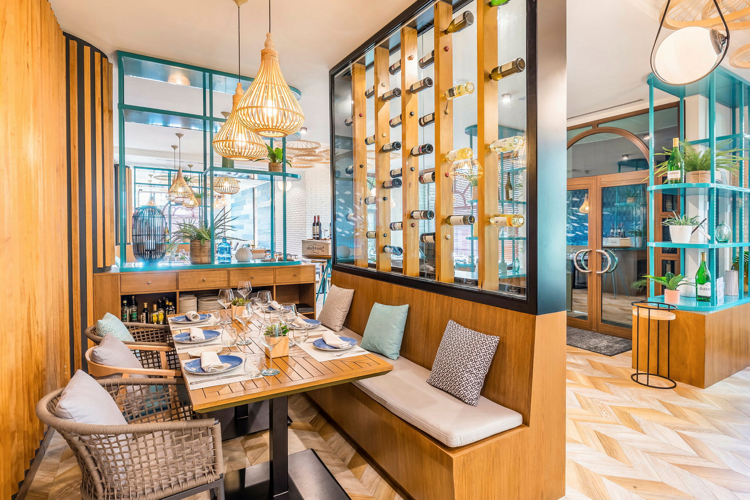 Ett elegant inrett restaurangutrymme med ett dukat bord för sex personer, moderna möbler och en transparent vinkylvägg. (AI-genererad text)