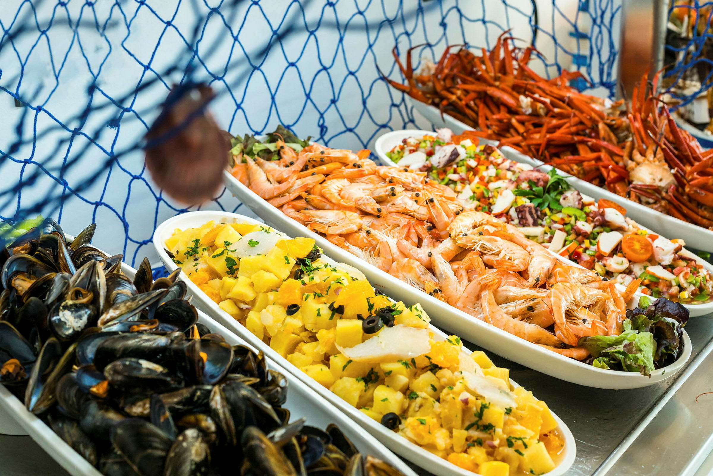 Uppställda fat med skaldjur, potatissallad och olika färgrika rätter. (AI-genererad text)