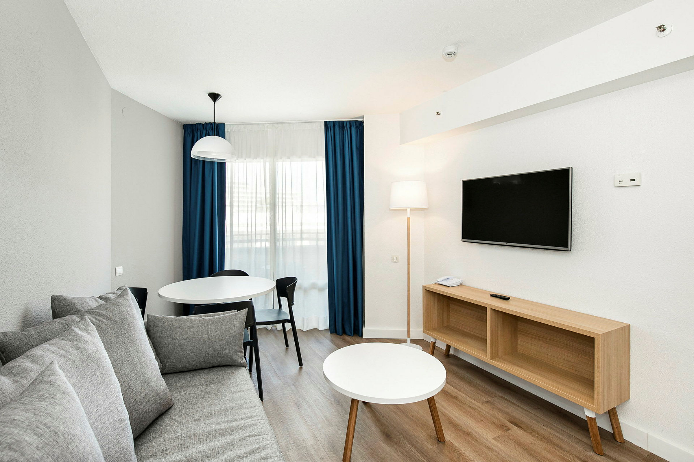 Ett modernt inrett vardagsrum med en soffa, matbord och tv. (AI-genererad text)