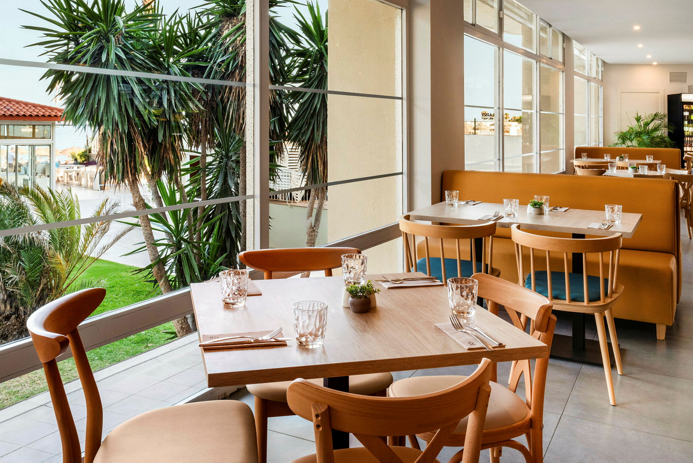 Restaurang med utsikt över trädgården och palmer. (AI-genererad text)