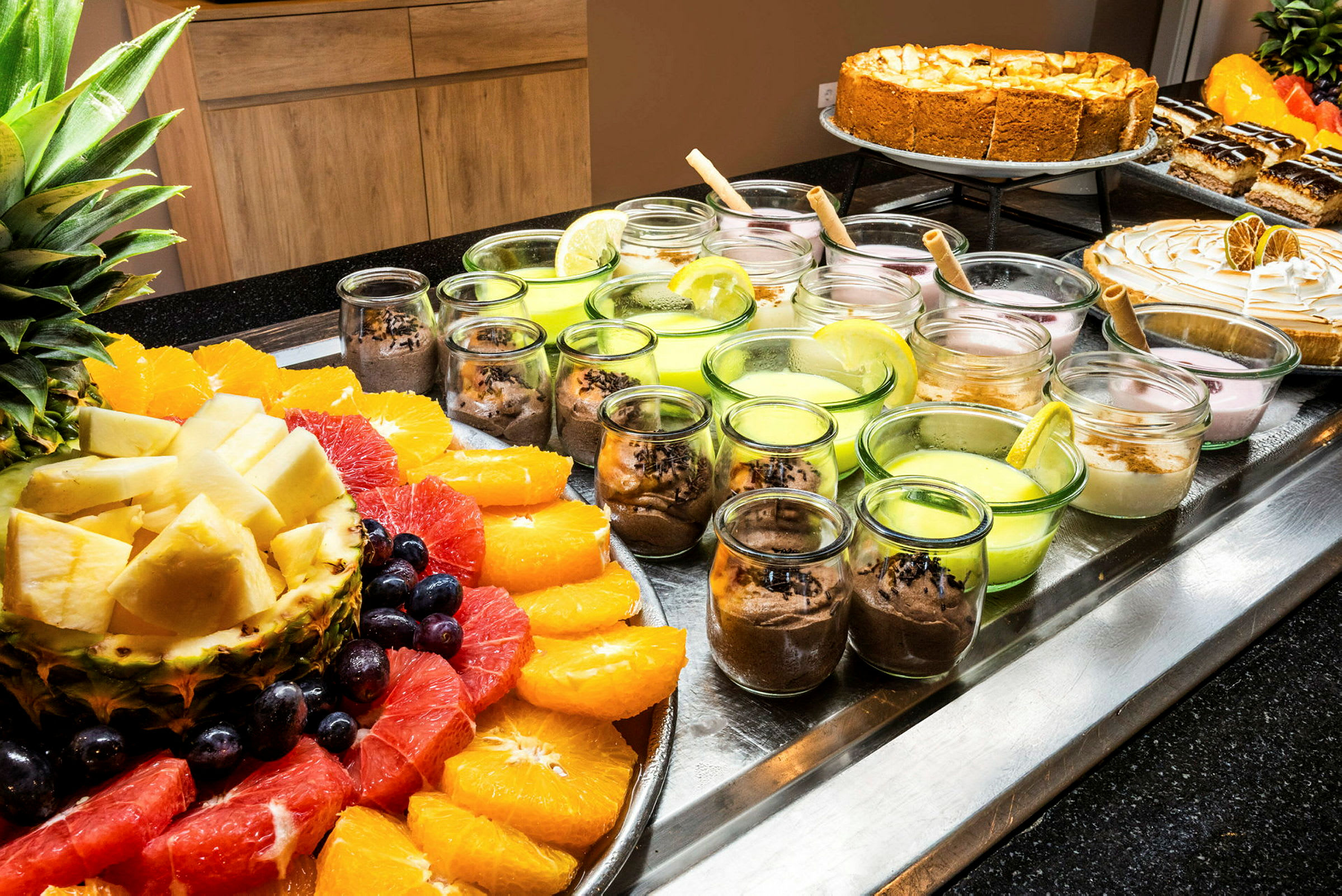 Ett upplägg med färsk frukt och desserter i små glas. (AI-genererad text)