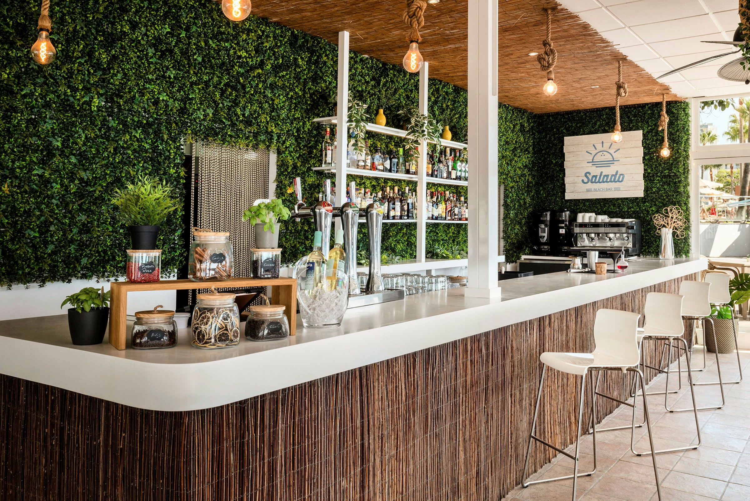 En strandbar med modern inredning, grönt väggdekoration och bardisk. (AI-genererad text)
