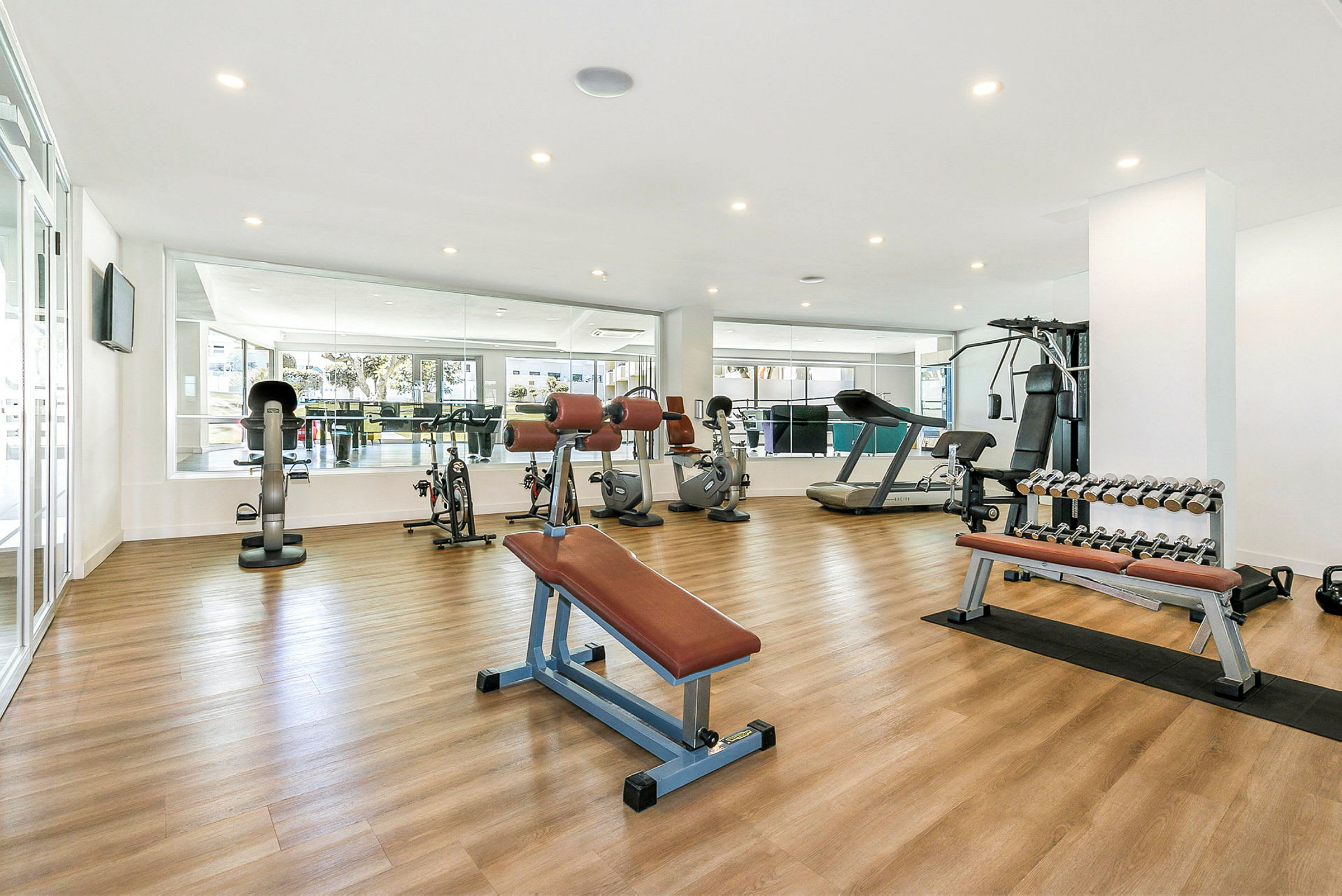 Ett gym med styrketräningsmaskiner, löpband, cyklar och hantlar. (AI-genererad text)