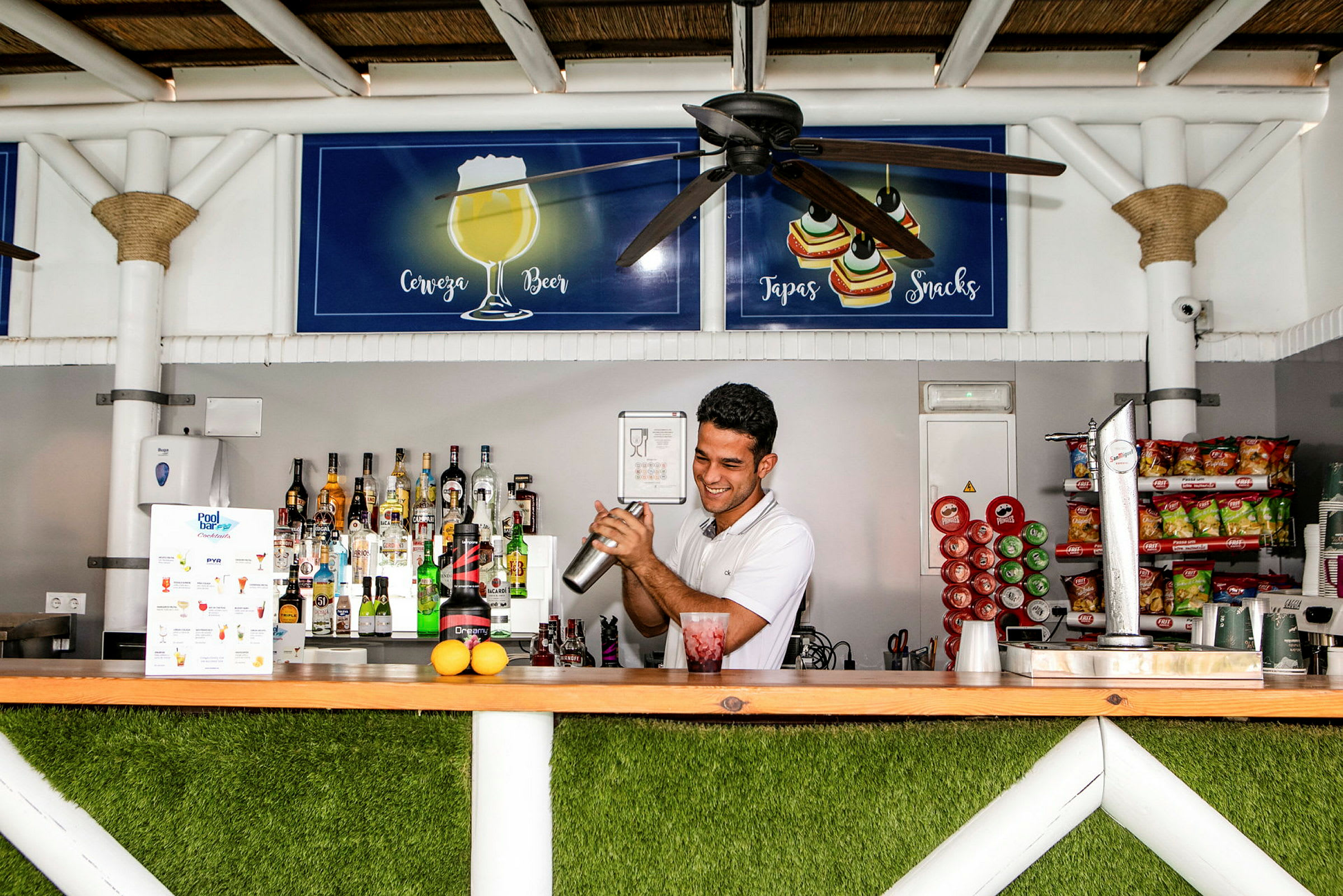 En person vid en bar blandar en drink. (AI-genererad text)