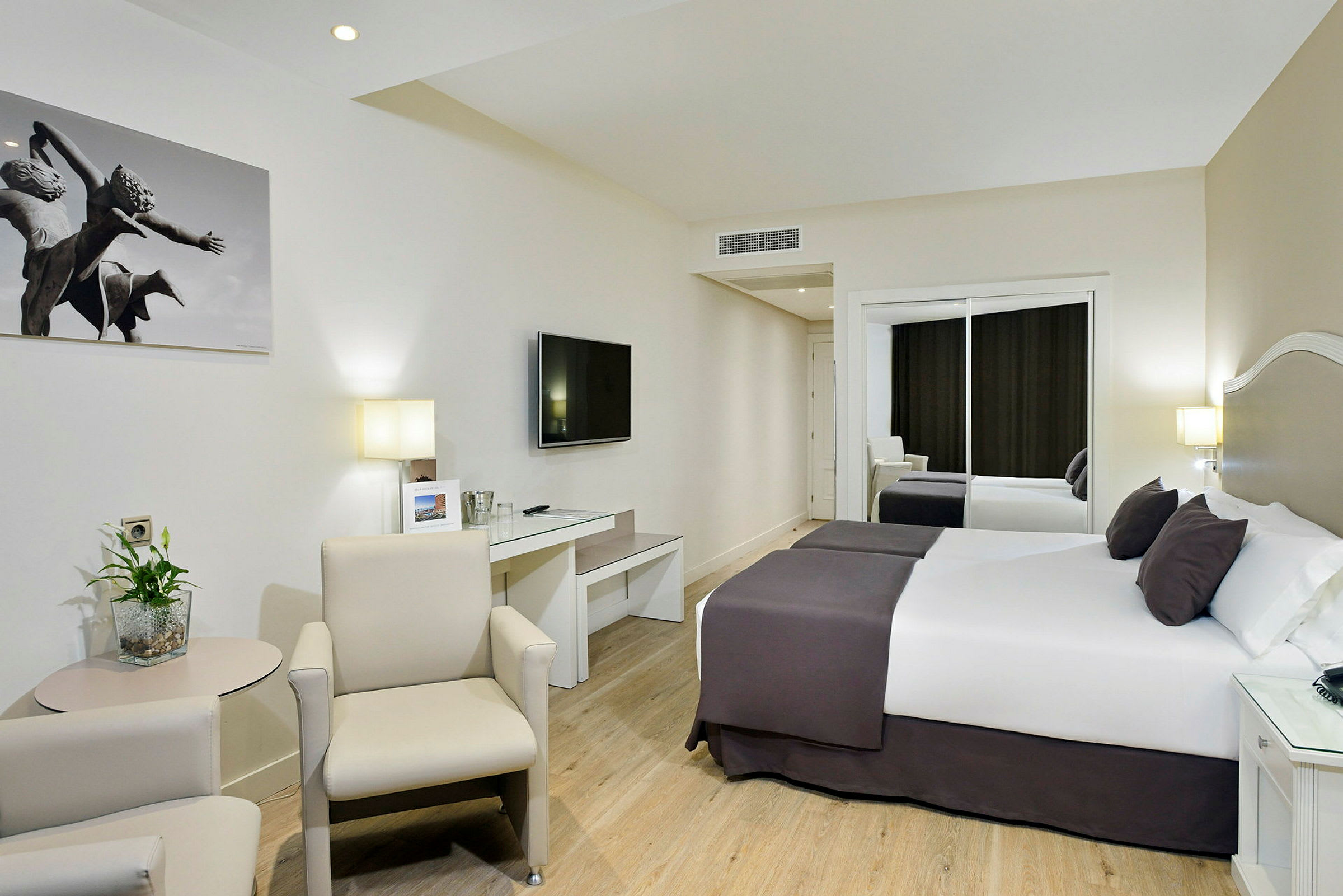 Ett hotellrum med två sängar, en tv och en sittgrupp. (AI-genererad text)
