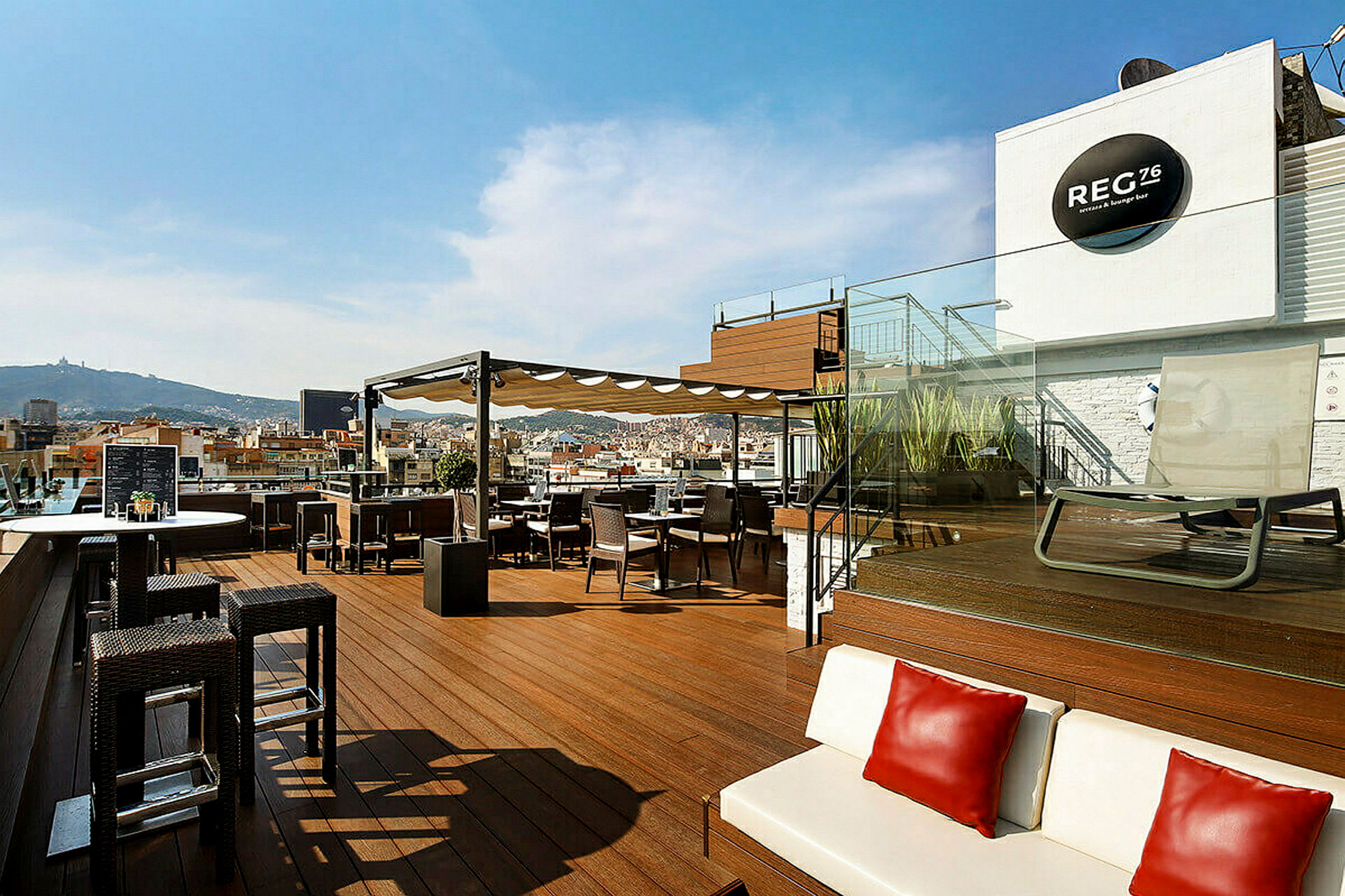 En takterrass med sittplatser, bord och en loungeområde med utsikt över staden. (AI-genererad text)