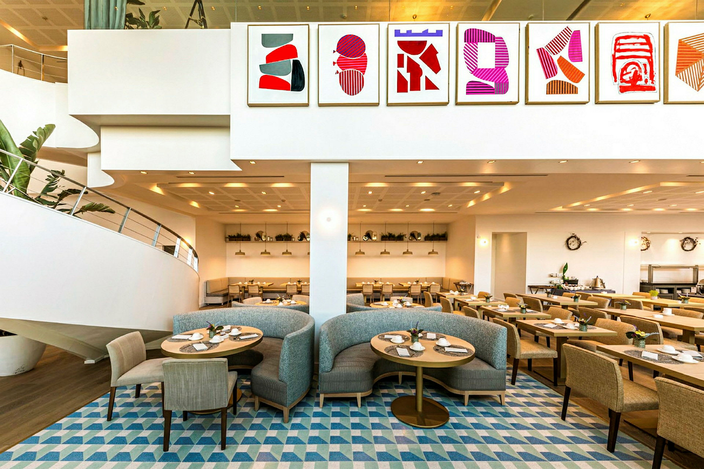 En restaurang med modern inredning, målningar på väggen och sittplatser med stolar och soffor. (AI-genererad text)