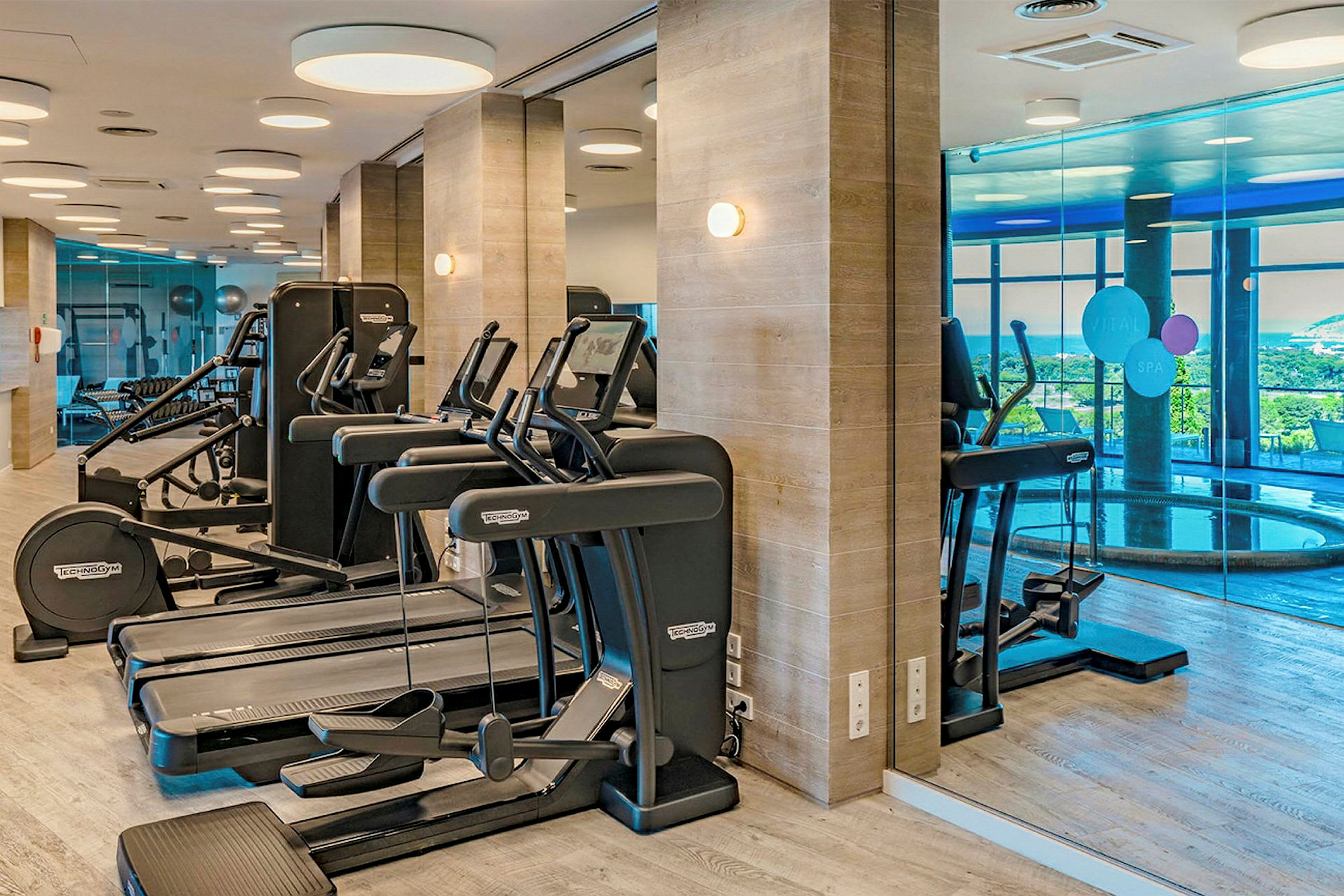Ett gym med träningsmaskiner och löpband framför speglade väggar. (AI-genererad text)