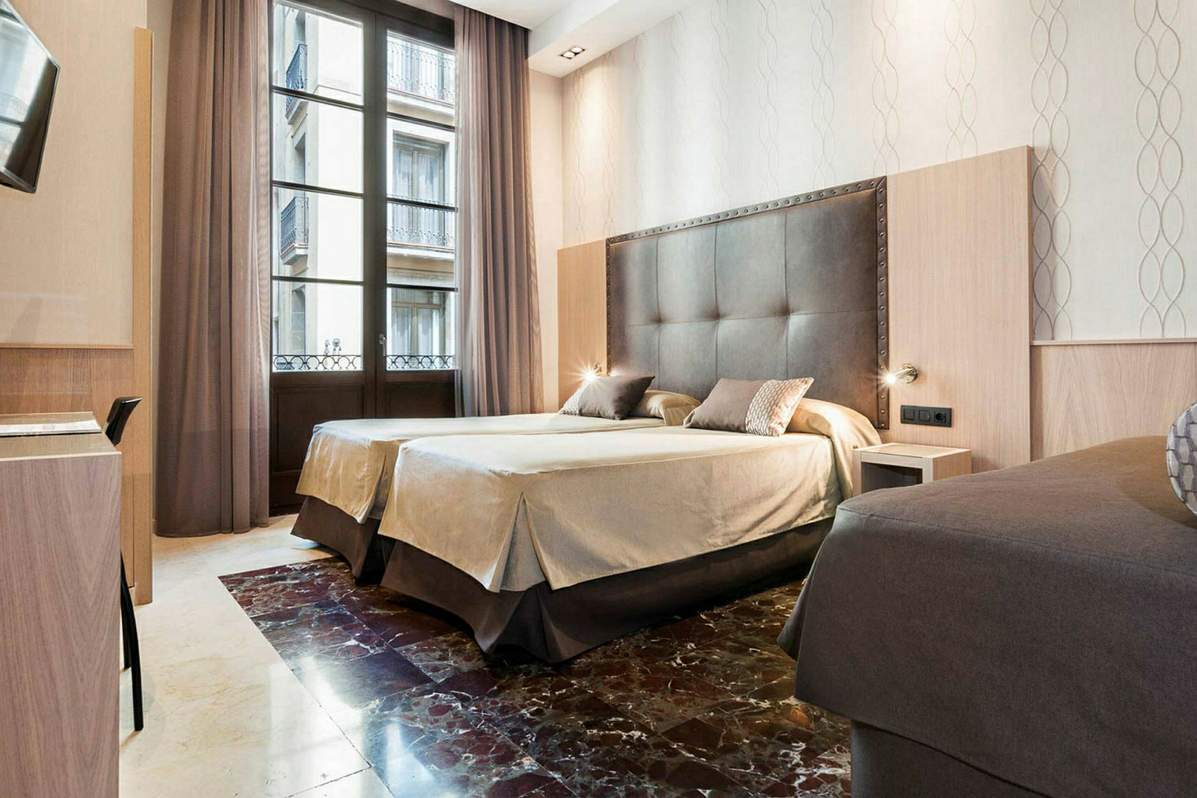 Ett hotellrum med två bäddade sängar, stora fönster med gardiner och en elegant interiör. (AI-genererad text)