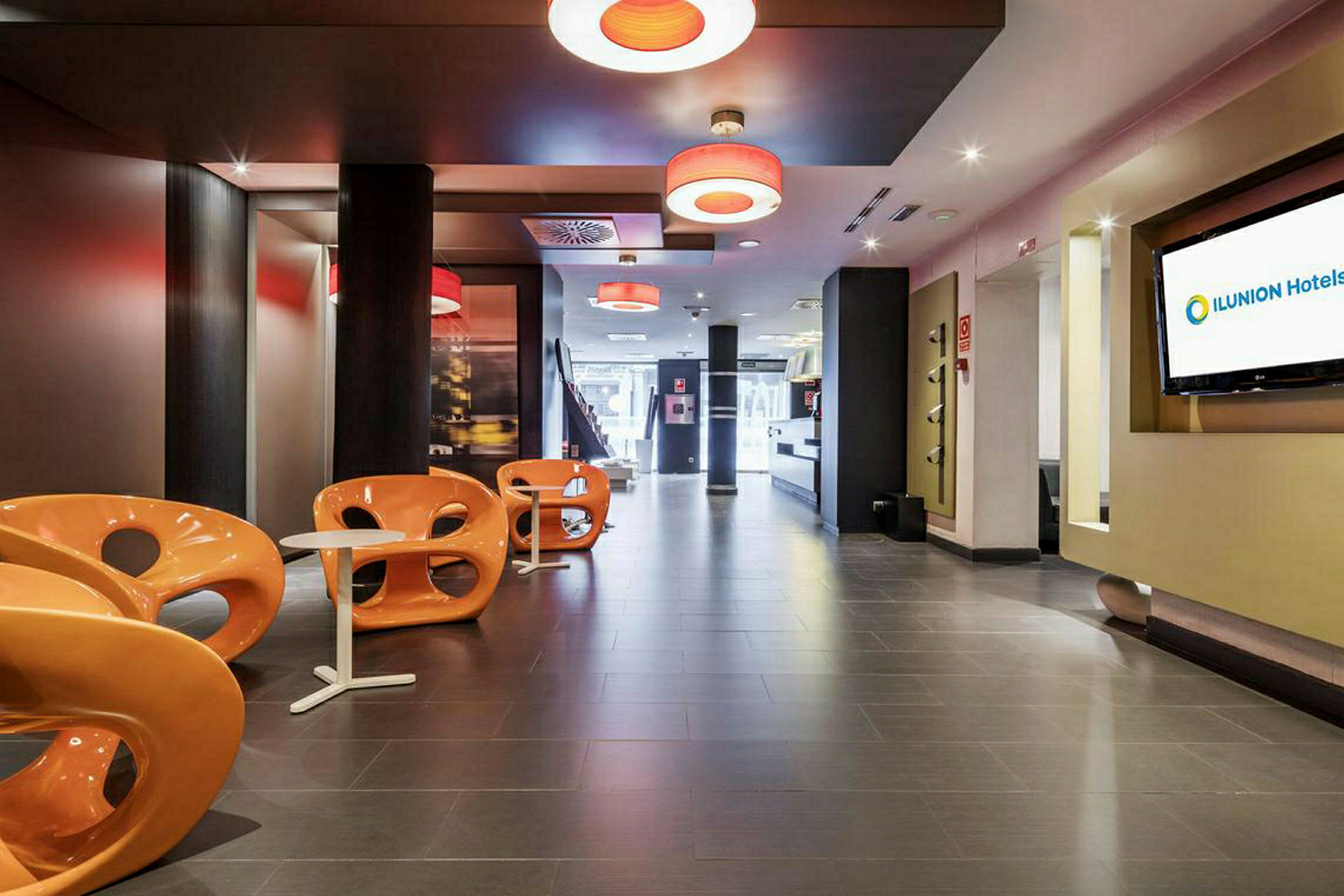 En modern hotellobby med orangea stolar och små vita bord. (AI-genererad text)