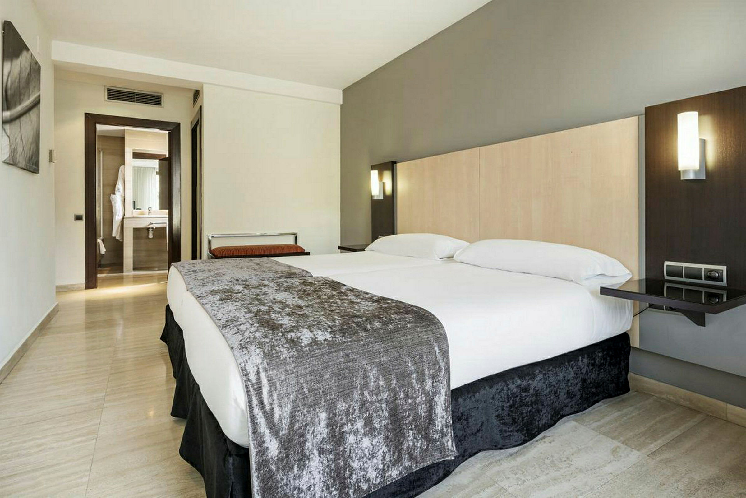 Ett modernt hotellrum med en stor säng och ett badrum i bakgrunden. (AI-genererad text)