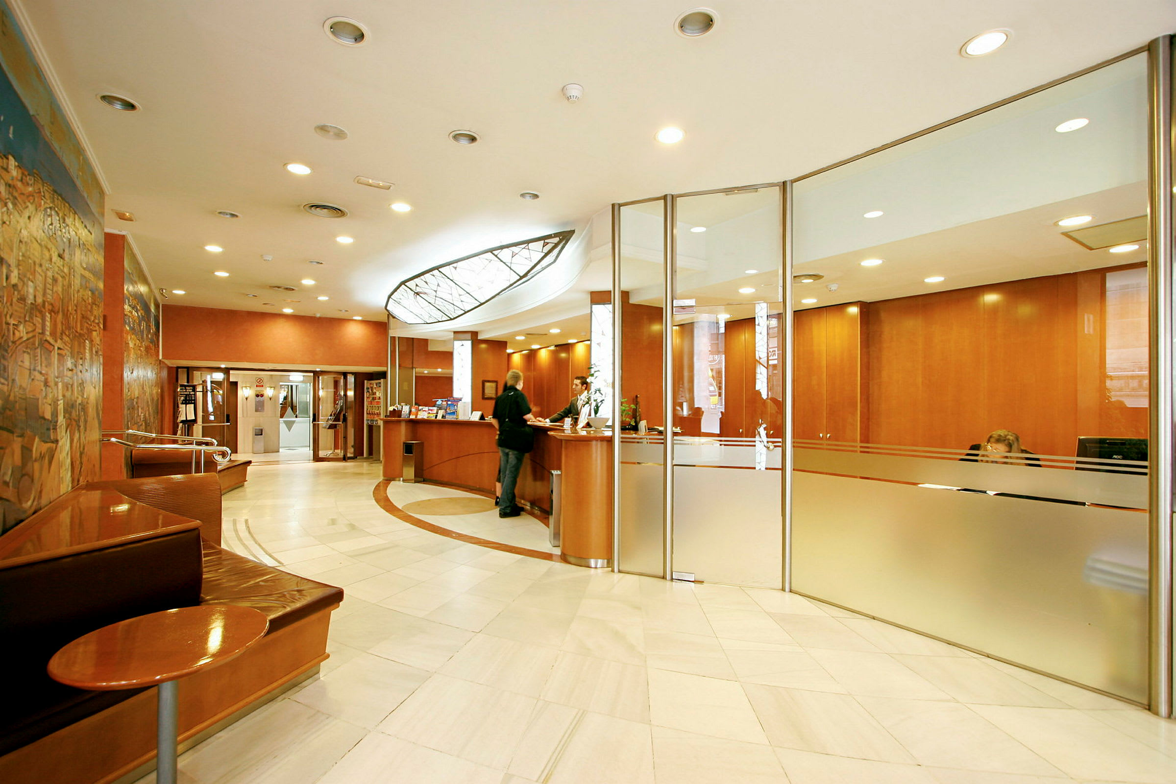 Ett hotellobby med en reception och sittplatser. (AI-genererad text)
