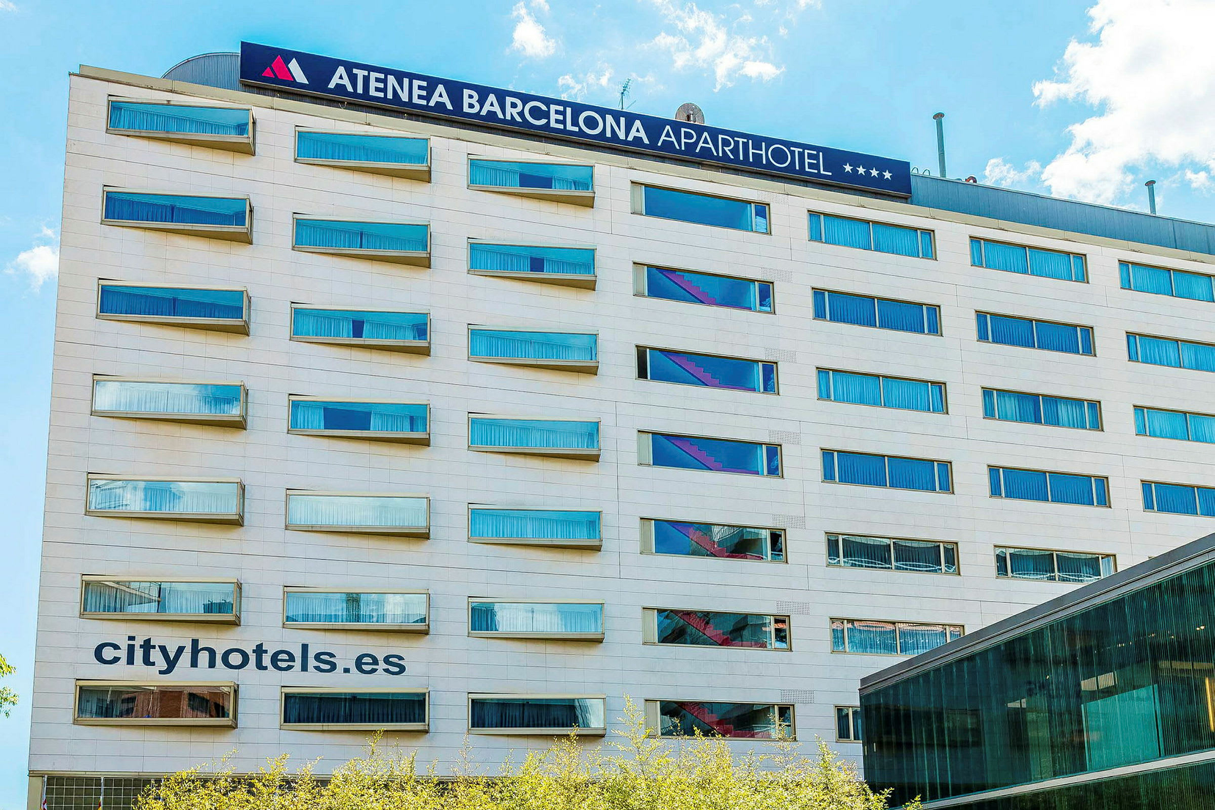 Ett flerbostadshus med skylt för Atenea Barcelona Aparthotel och texten cityhotels.es synlig på fasaden. (AI-genererad text)