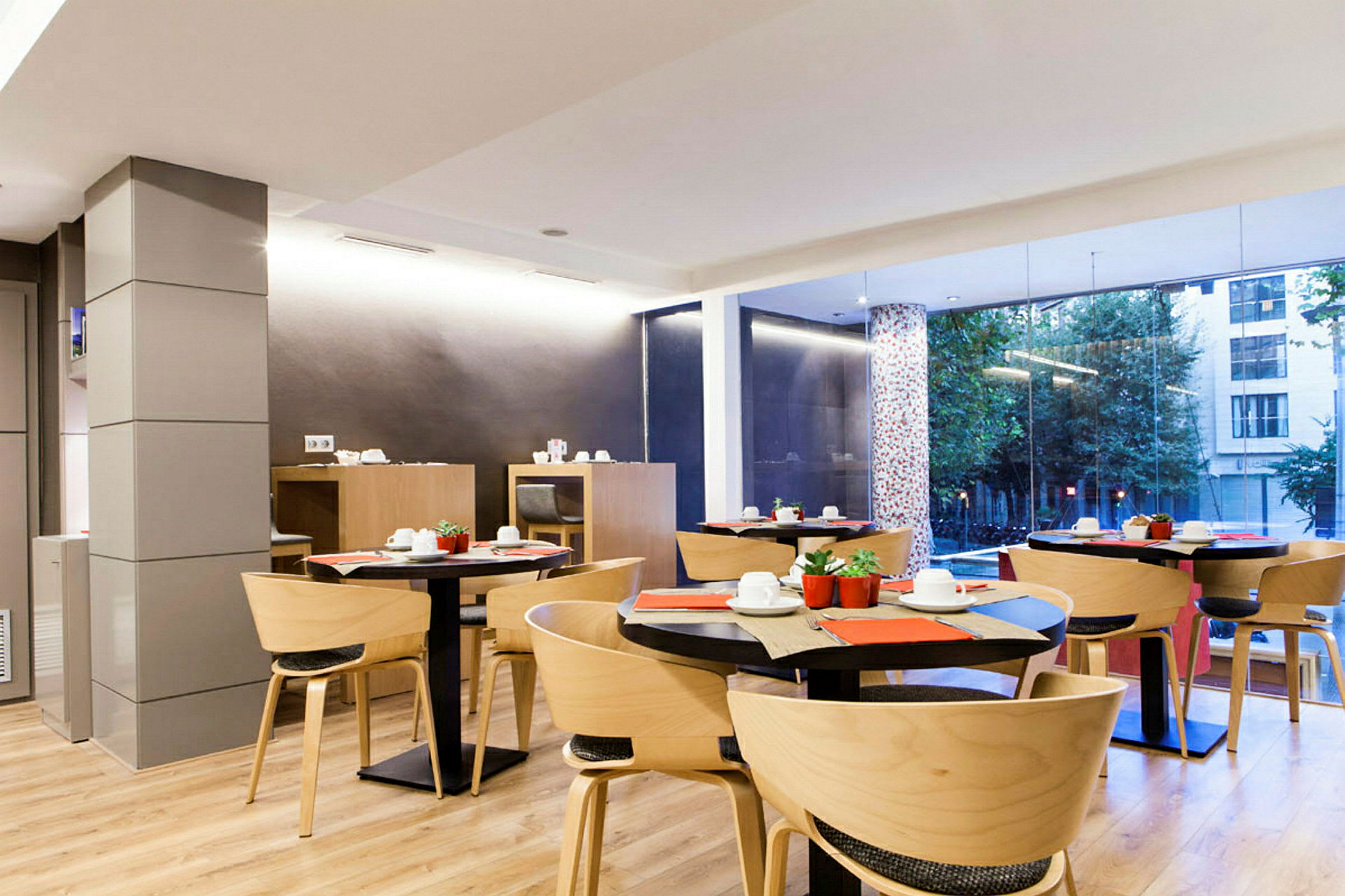 Restaurang med moderna trämöbler och stora glasfönster. (AI-genererad text)