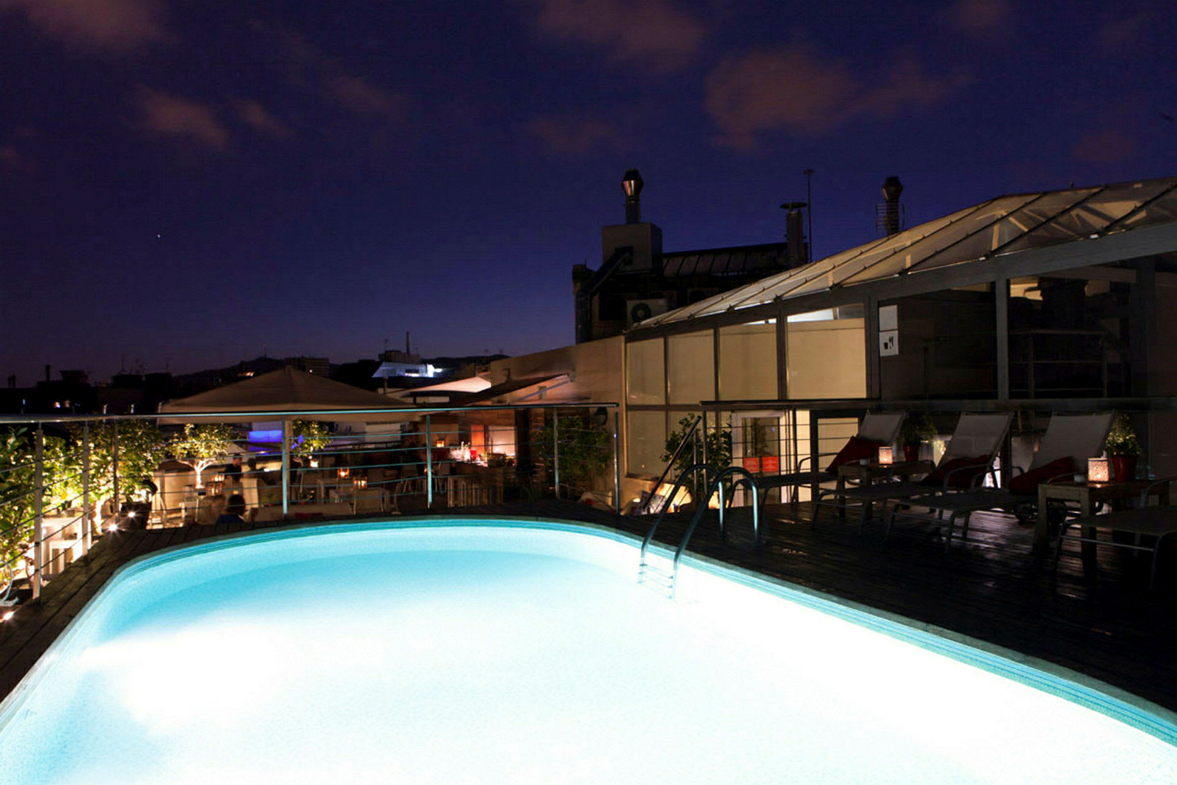 Upplyst pool på ett tak vid skymning. (AI-genererad text)