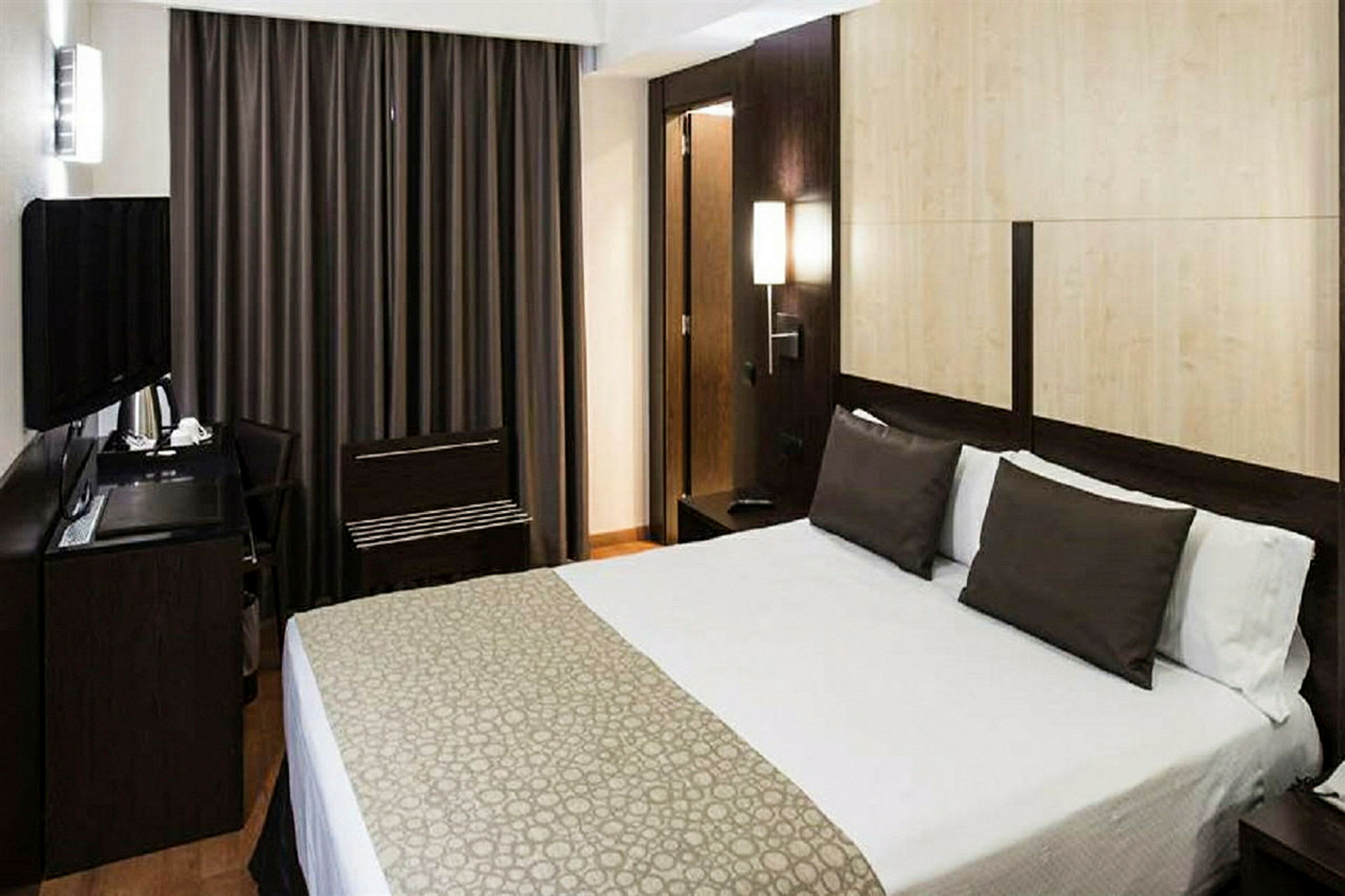 Modernt inrett hotellrum med en stor säng. (AI-genererad text)