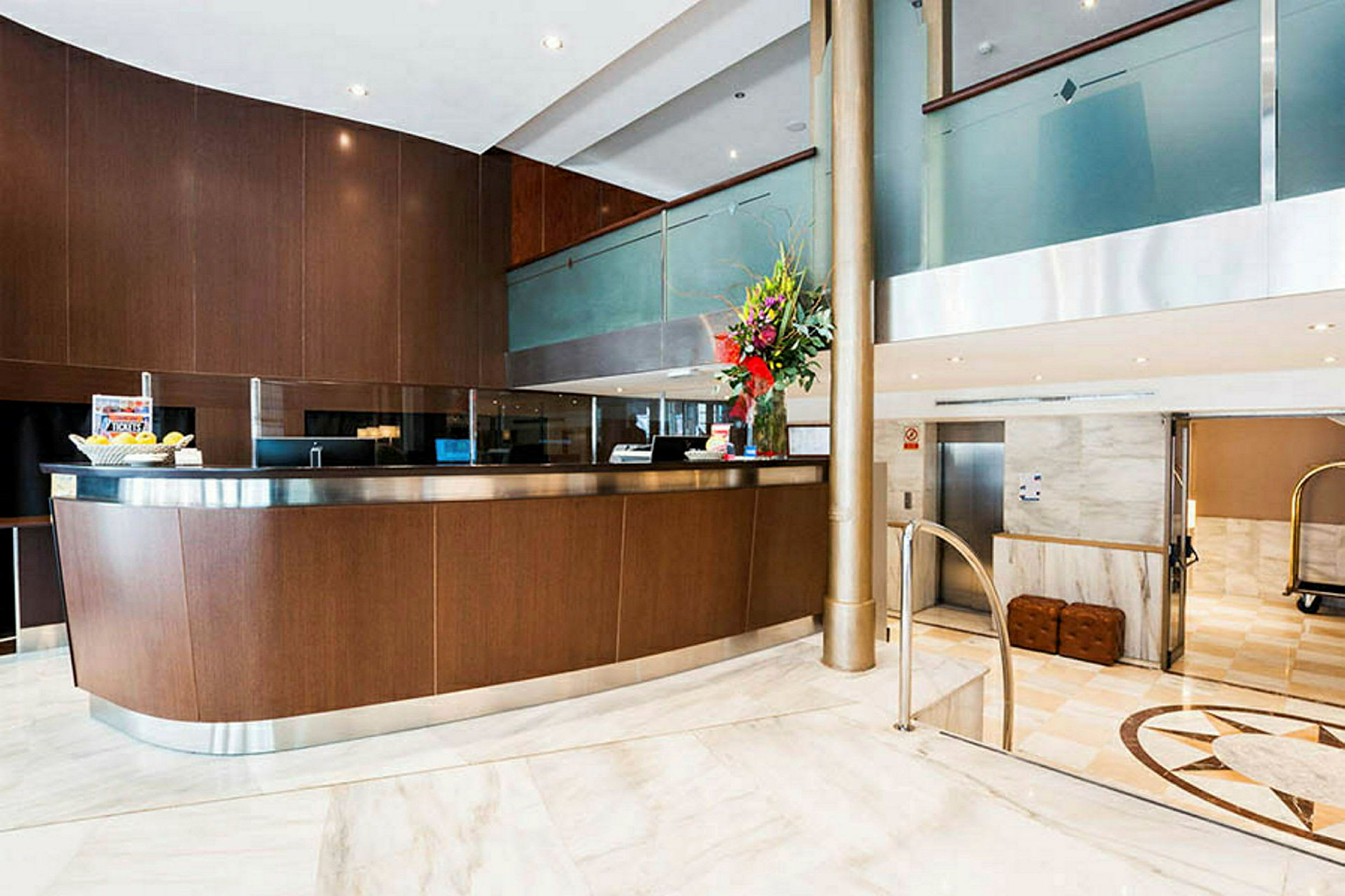 Receptionen i en modern hotellobby med en träpanel och marmorgolv. (AI-genererad text)