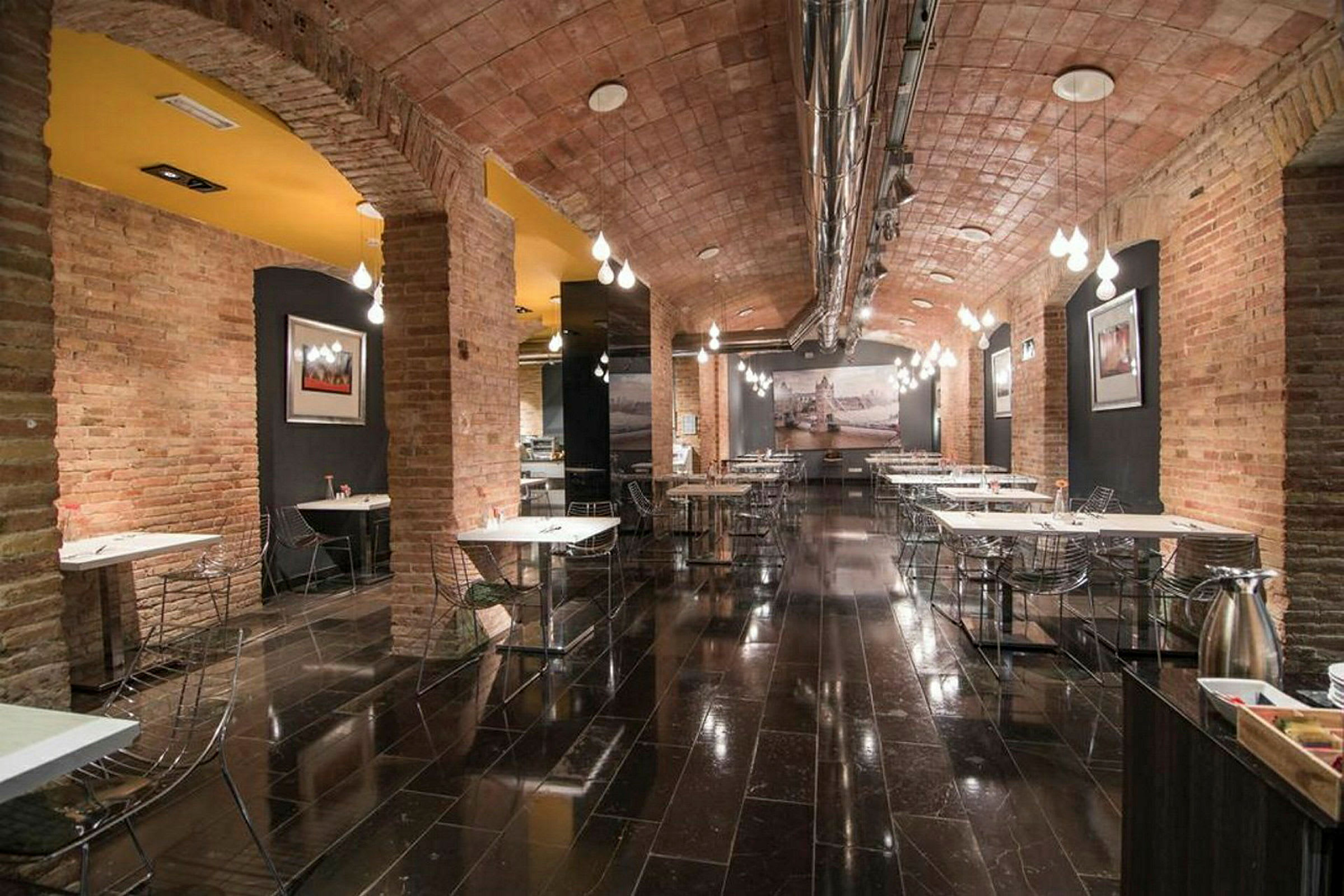 Restaurangtäta med tegelvalv, blanka golv och modernt möblemang. (AI-genererad text)