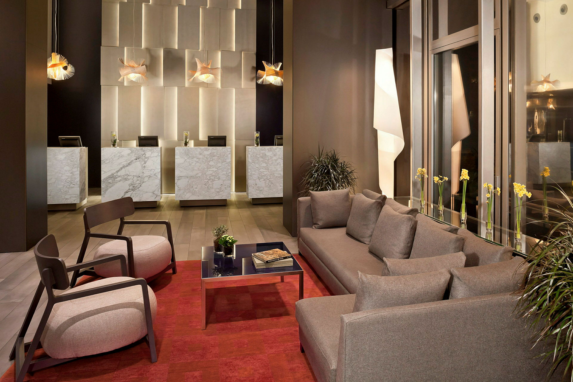 Bild av en hotellobby med marmordiskar, moderna soffor och fåtöljer samt dekorativa lampor. (AI-genererad text)