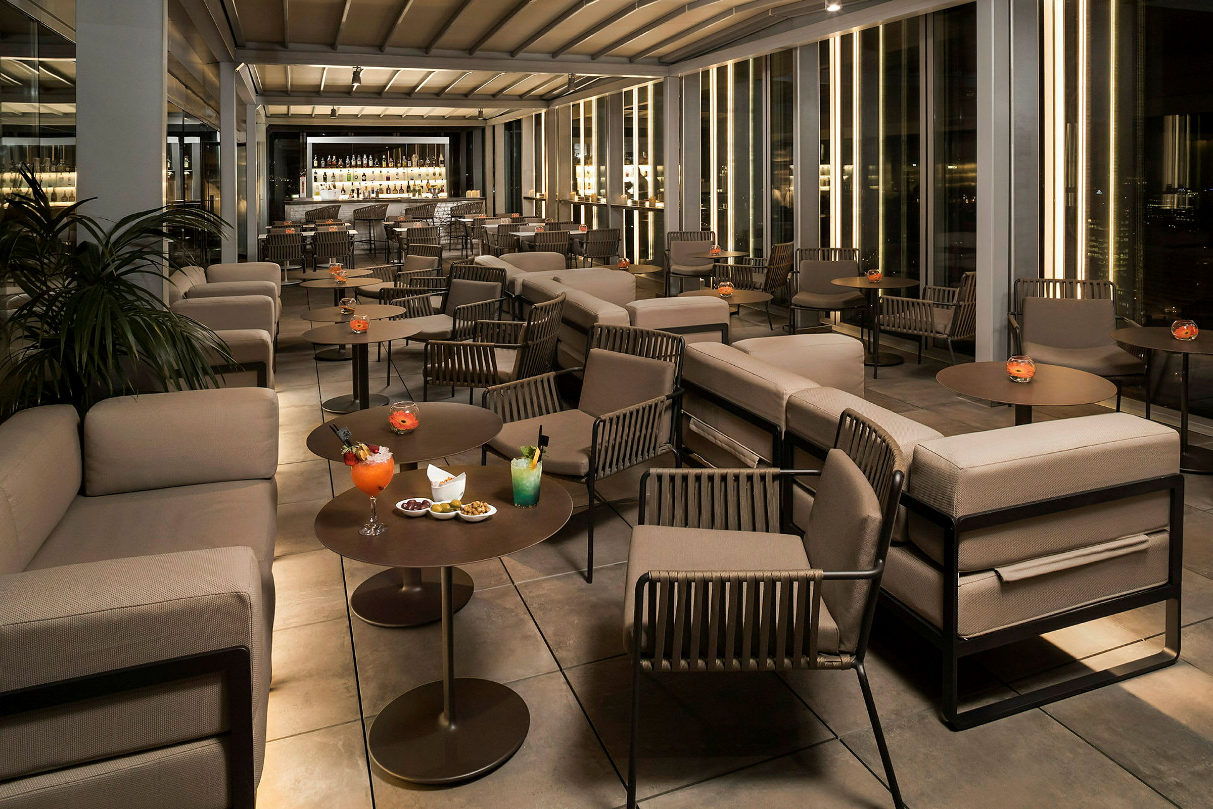 En modern lounge med soffor, bord och drycker på en elegant plats. (AI-genererad text)