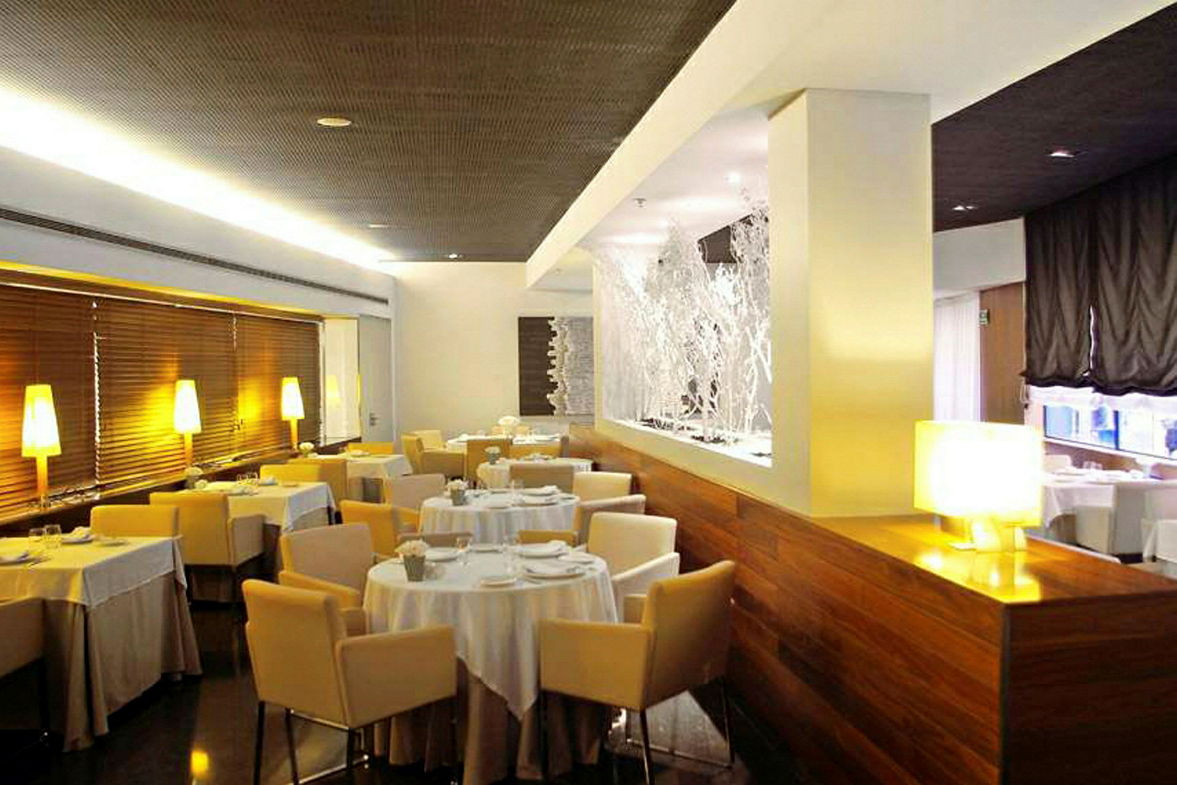 En modern och elegant restaurang med uppdukade bord och bekväma stolar. (AI-genererad text)