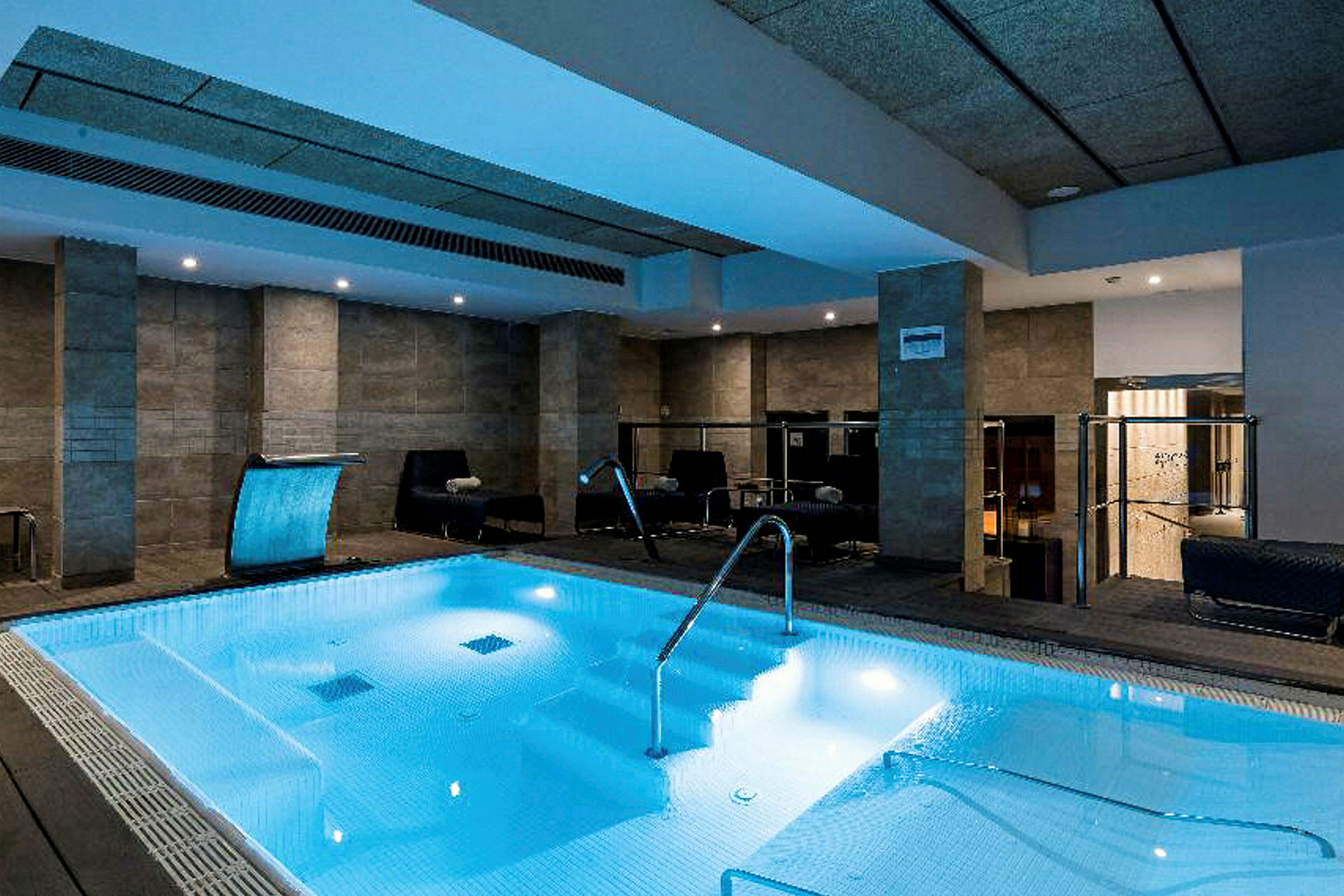 Inomhuspool med sittplatser runt om. (AI-genererad text)