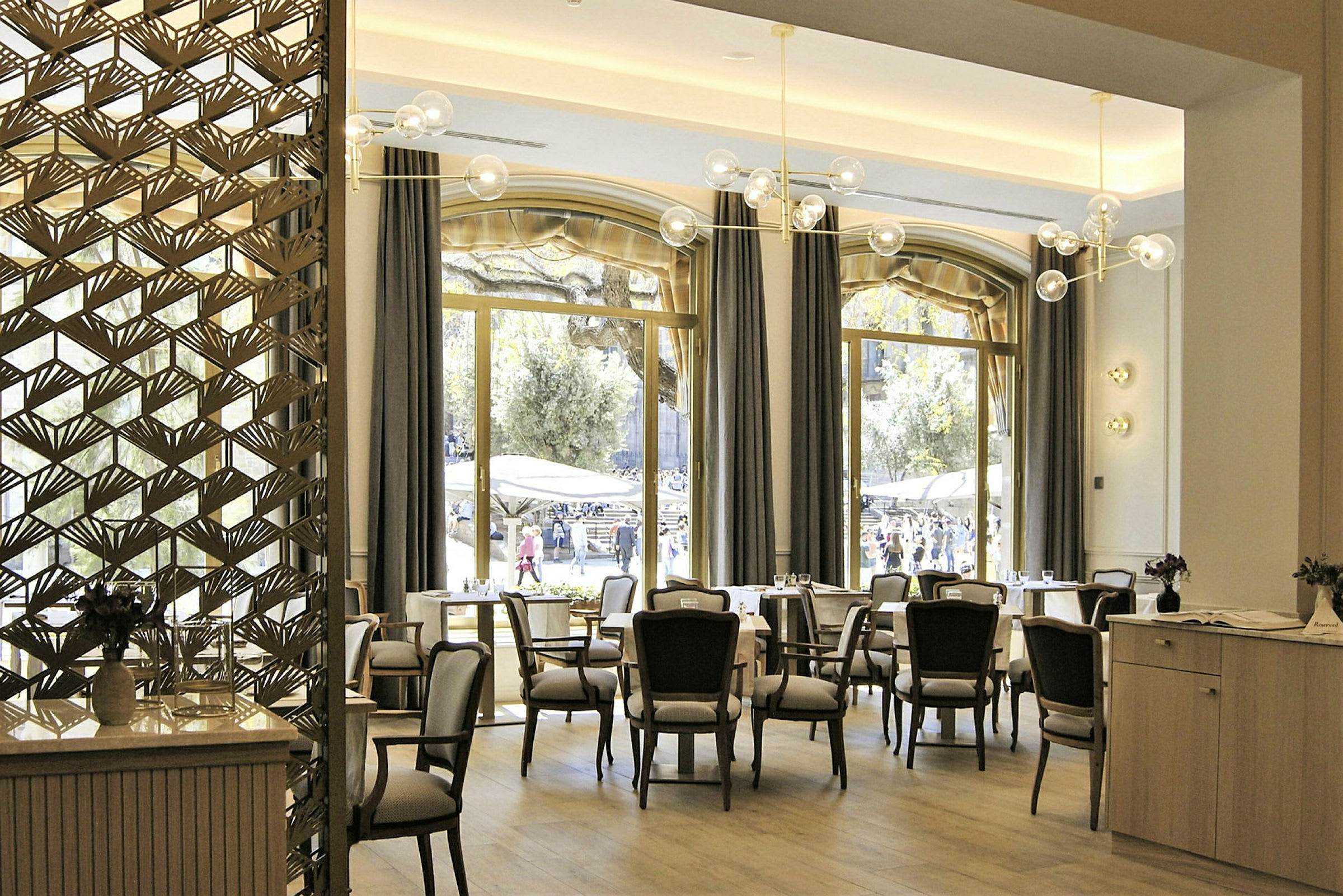 Interiör av en restaurang med stora fönster och eleganta möbler. (AI-genererad text)
