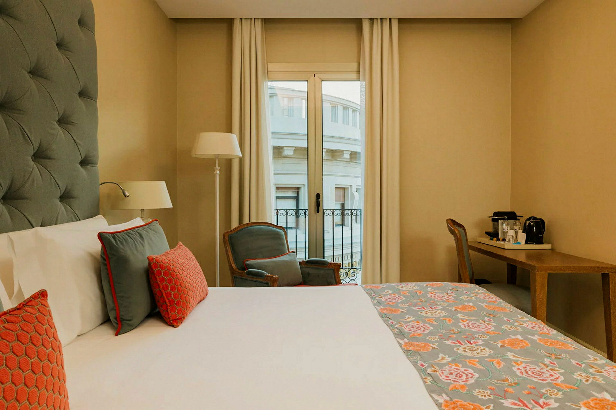 Ett hotellrum med en säng, stol, skrivbord och fönster. (AI-genererad text)
