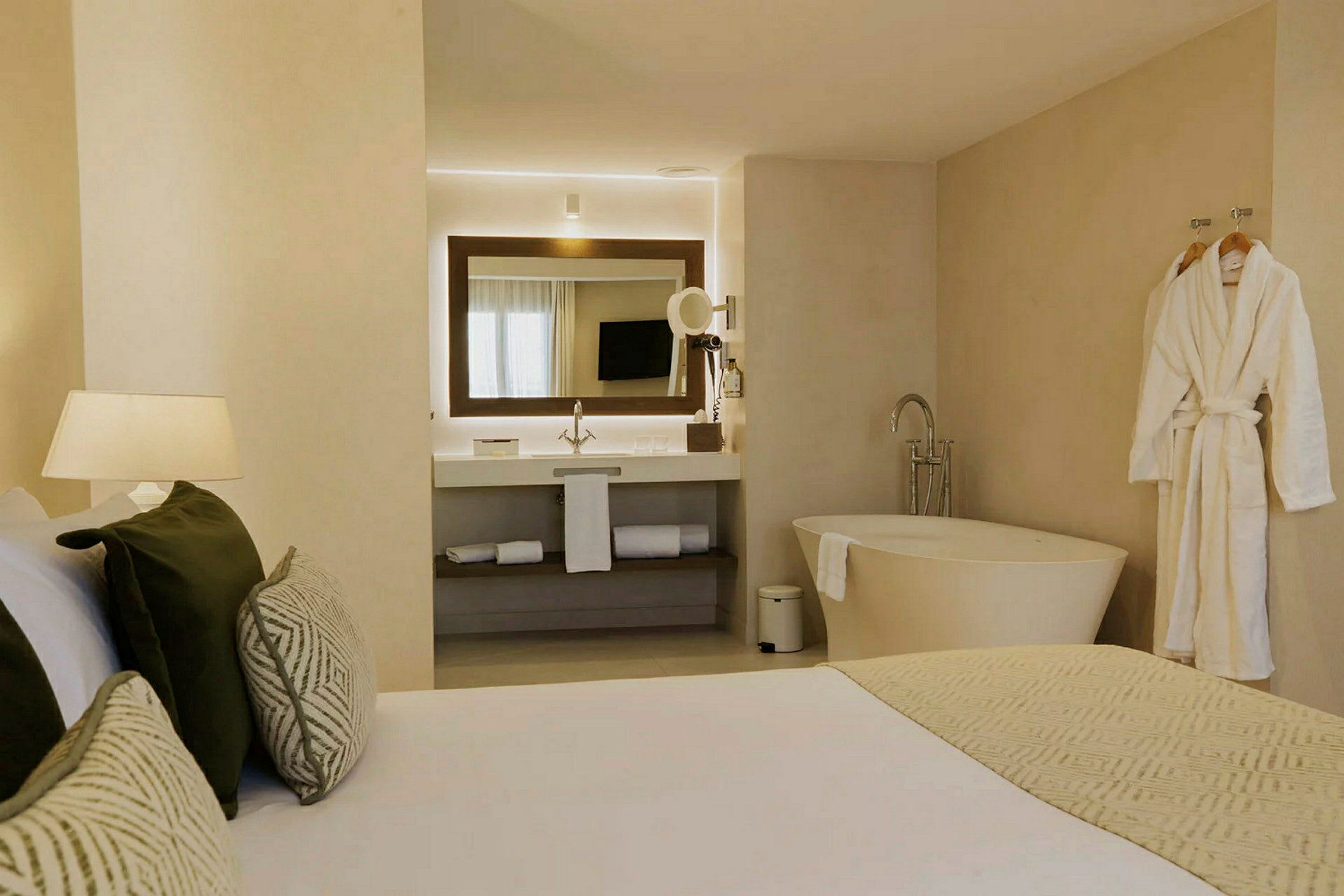 Modernt hotellrum med badrum, säng och badkar. (AI-genererad text)