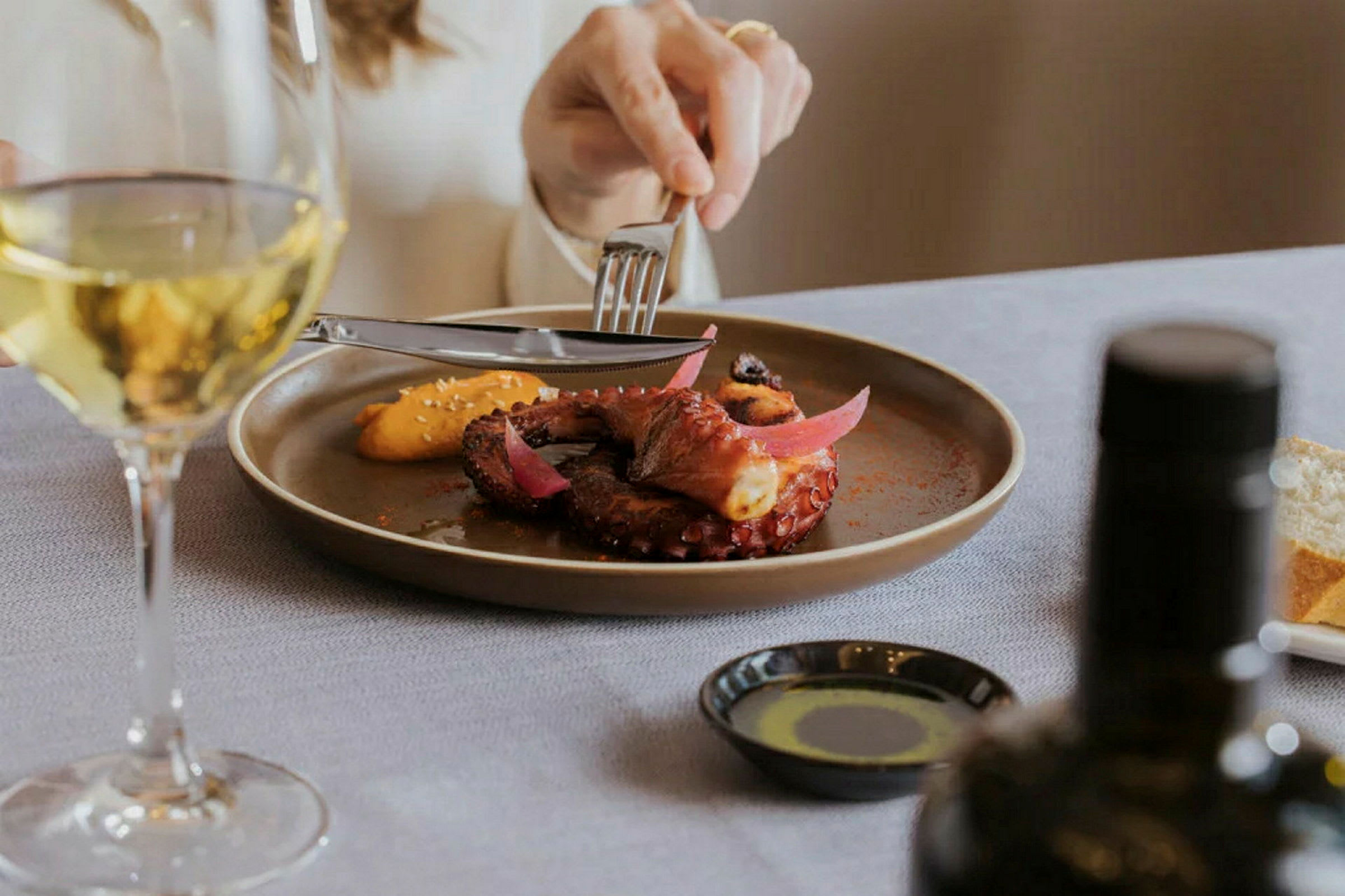 En elegant serverad måltid med tillhörande glas vitt vin. (AI-genererad text)
