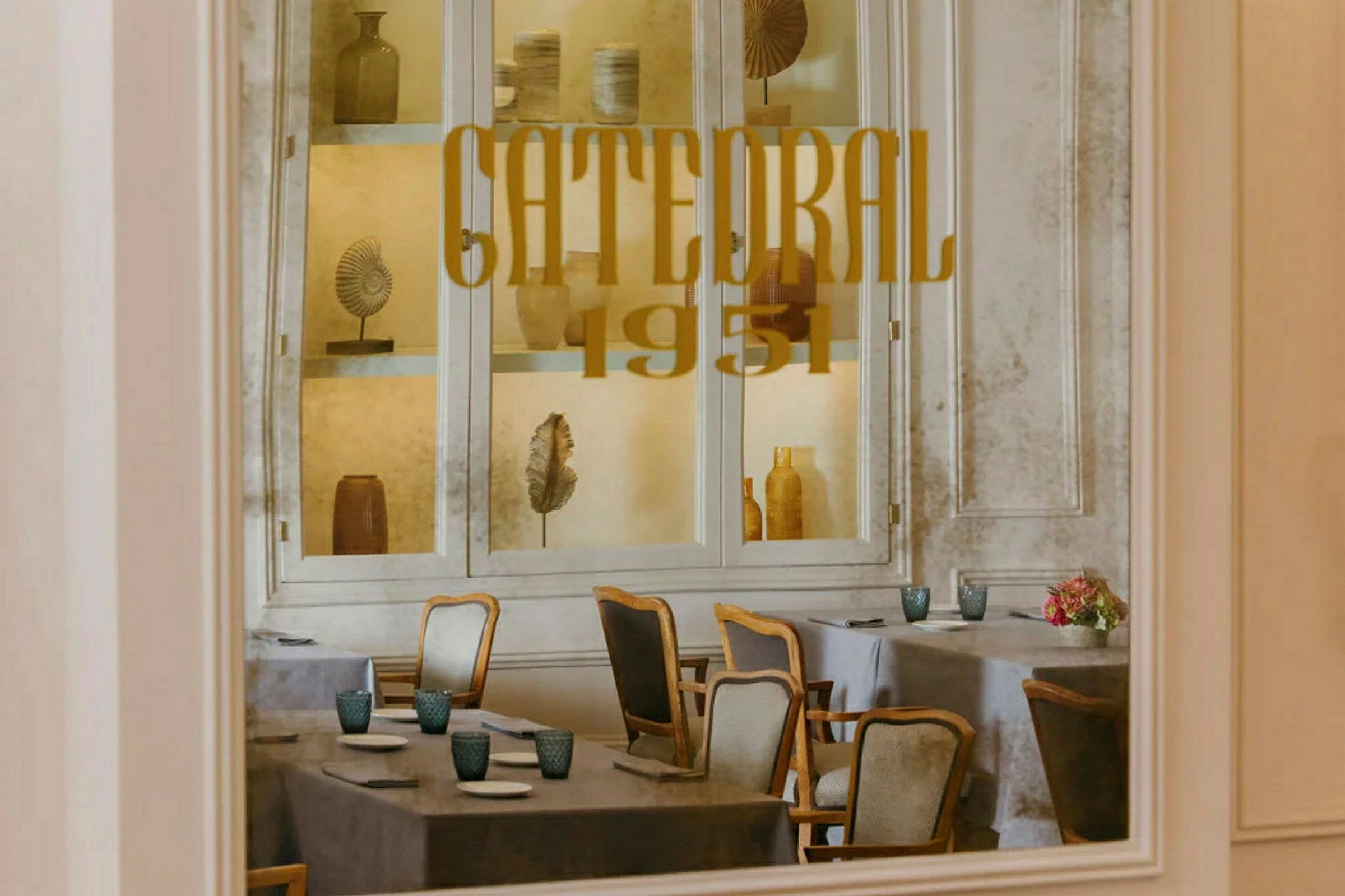 Interiören av en restaurang med bordsdukning och dekorationer bakom glas. (AI-genererad text)