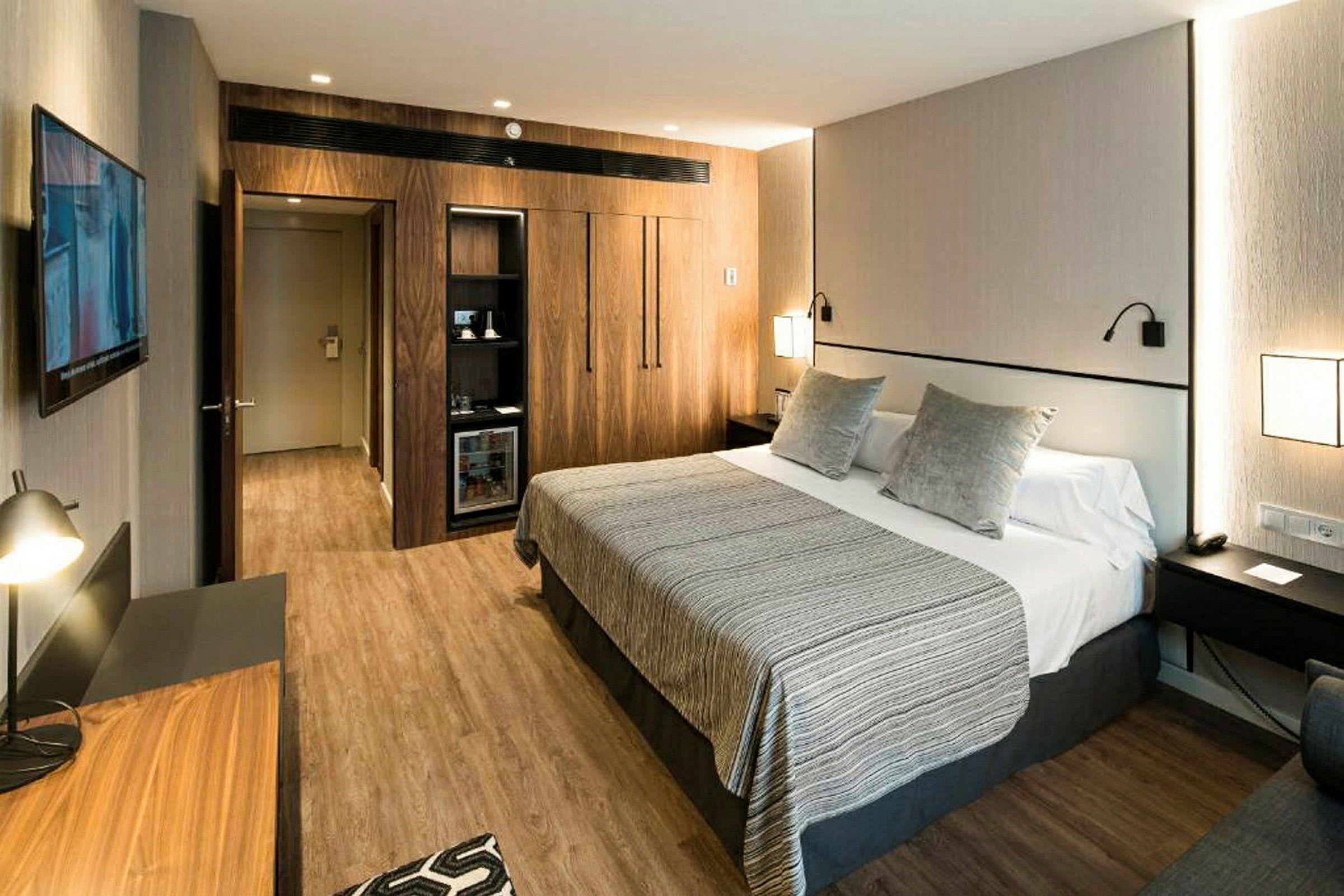 Hotellrum med stor säng, modern inredning och trädetaljer. (AI-genererad text)