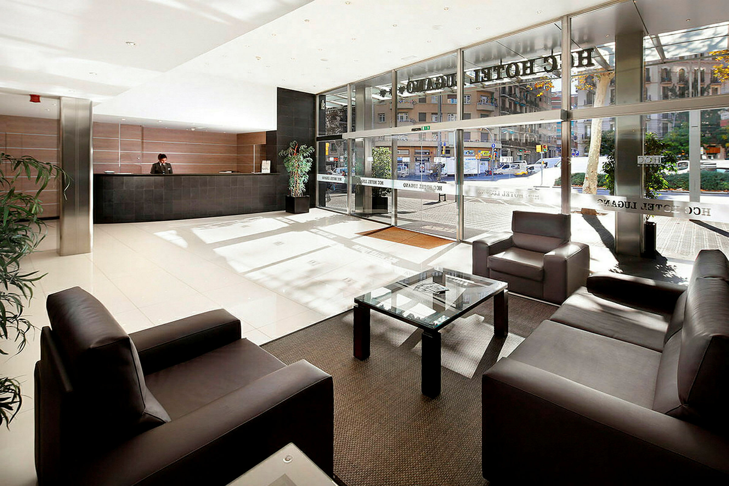 Hotellobby med sittmöbler, reception och stora glasfönster. (AI-genererad text)