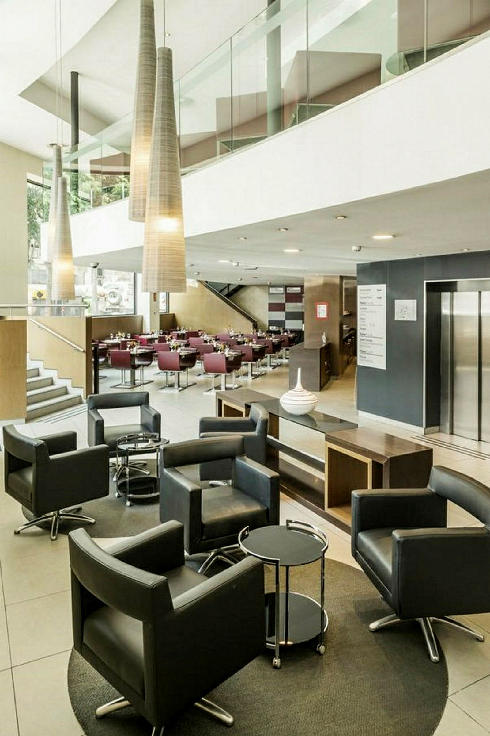 Ett modernt hotellrum med möblerade stolar och bord. (AI-genererad text)
