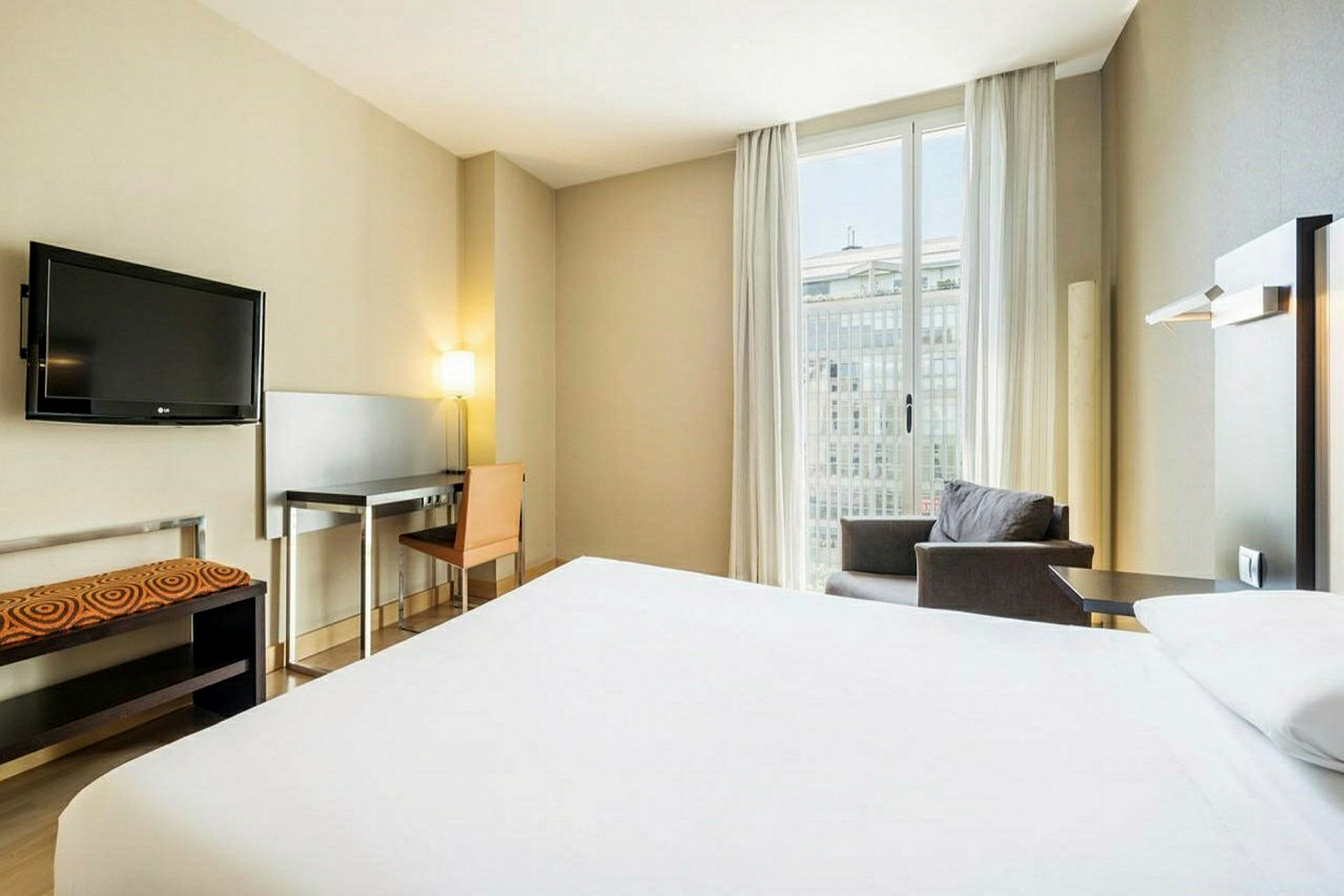 Ett hotellrum med en säng och ett skrivbord. (AI-genererad text)
