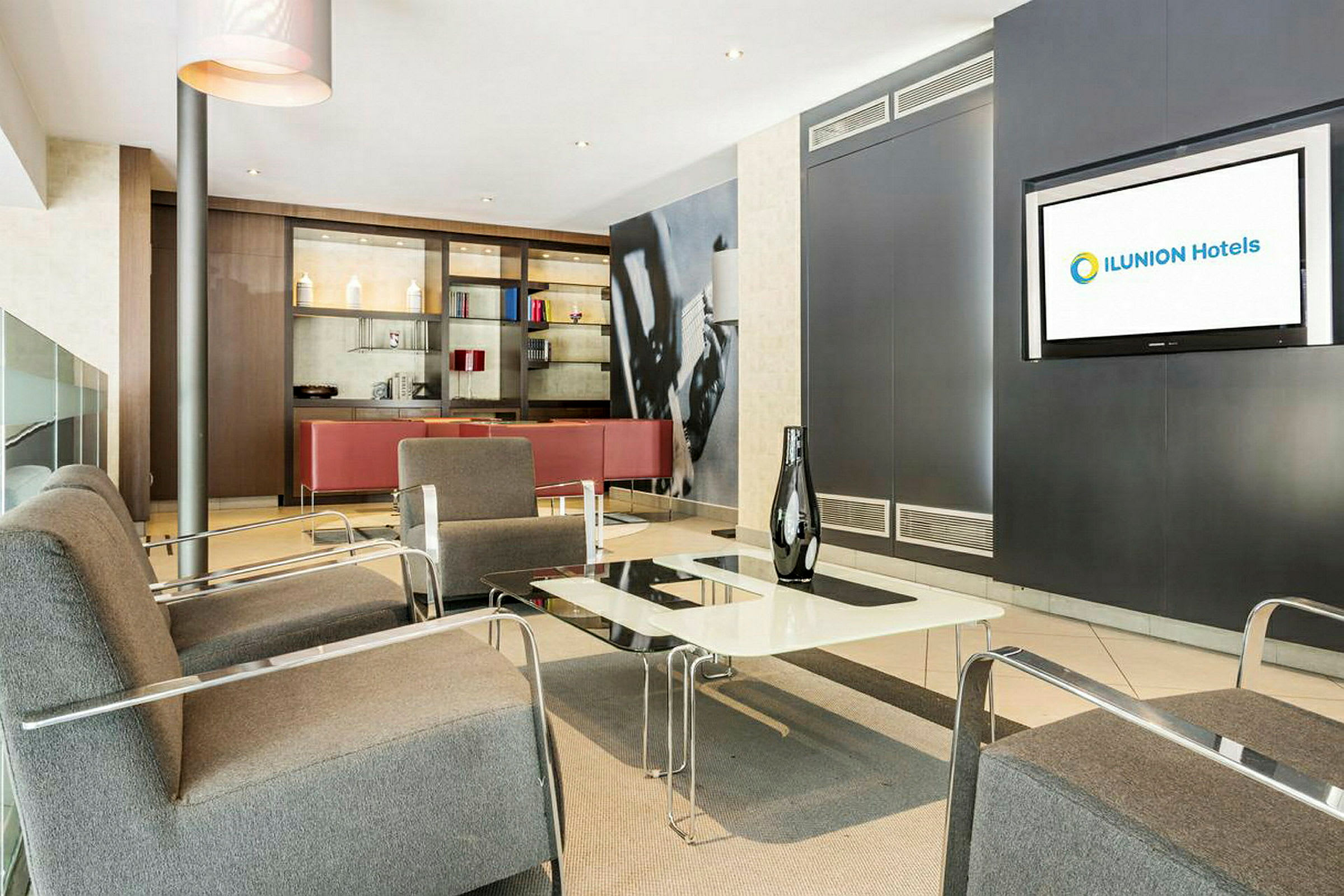 Ett hotellrum med sittplatser och ett teveskärm. (AI-genererad text)