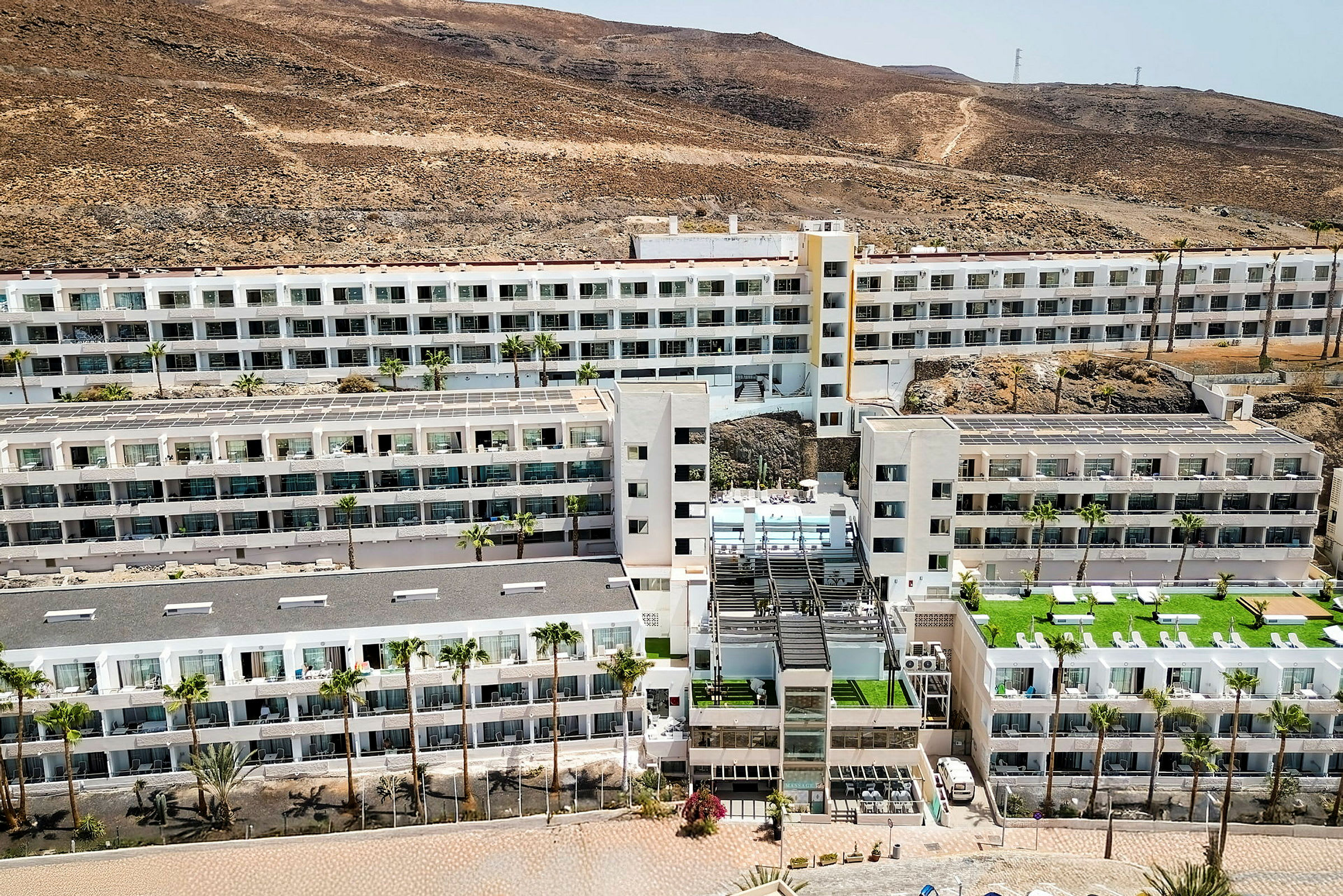 Ett stort hotellkomplex omgivet av ett torrt, bergigt landskap. (AI-genererad text)