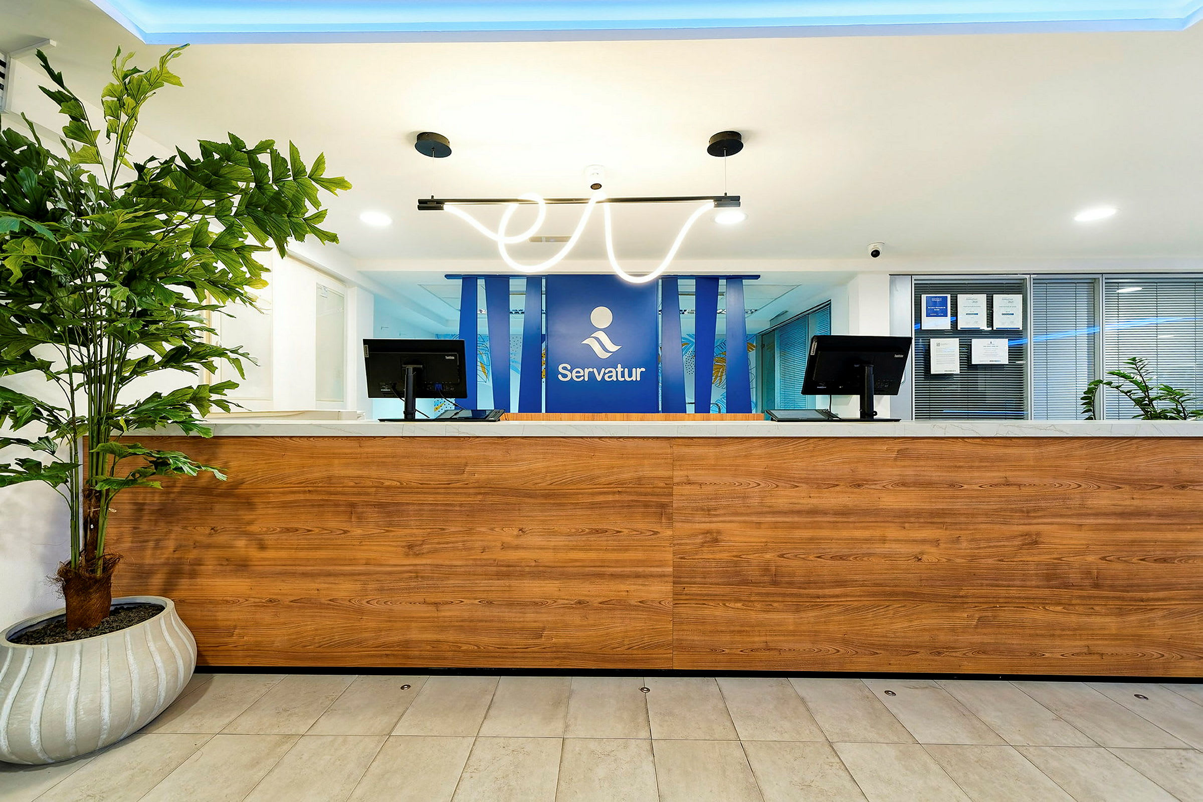 En reception med en träpanel och en blå logotypbakgrund. (AI-genererad text)