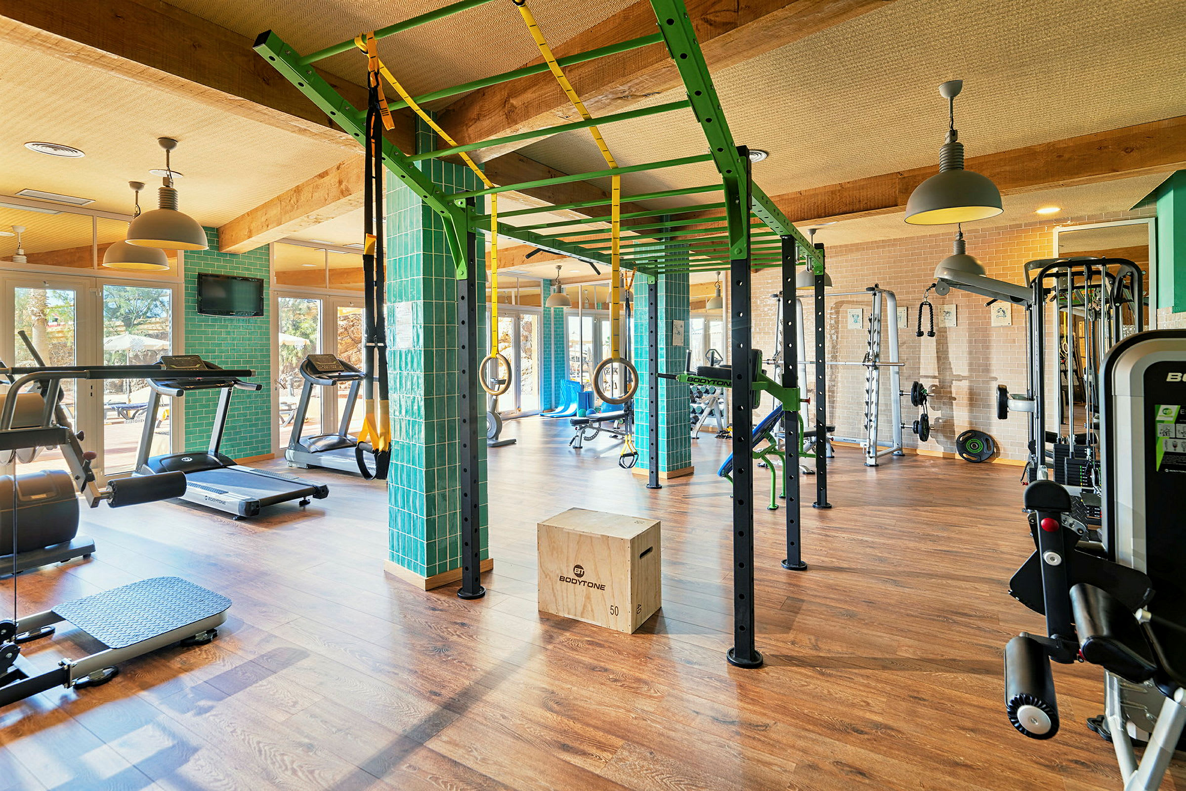 Ett gym med olika träningsredskap, såsom löpband, hoppramar, vikter och träningsbänkar. (AI-genererad text)