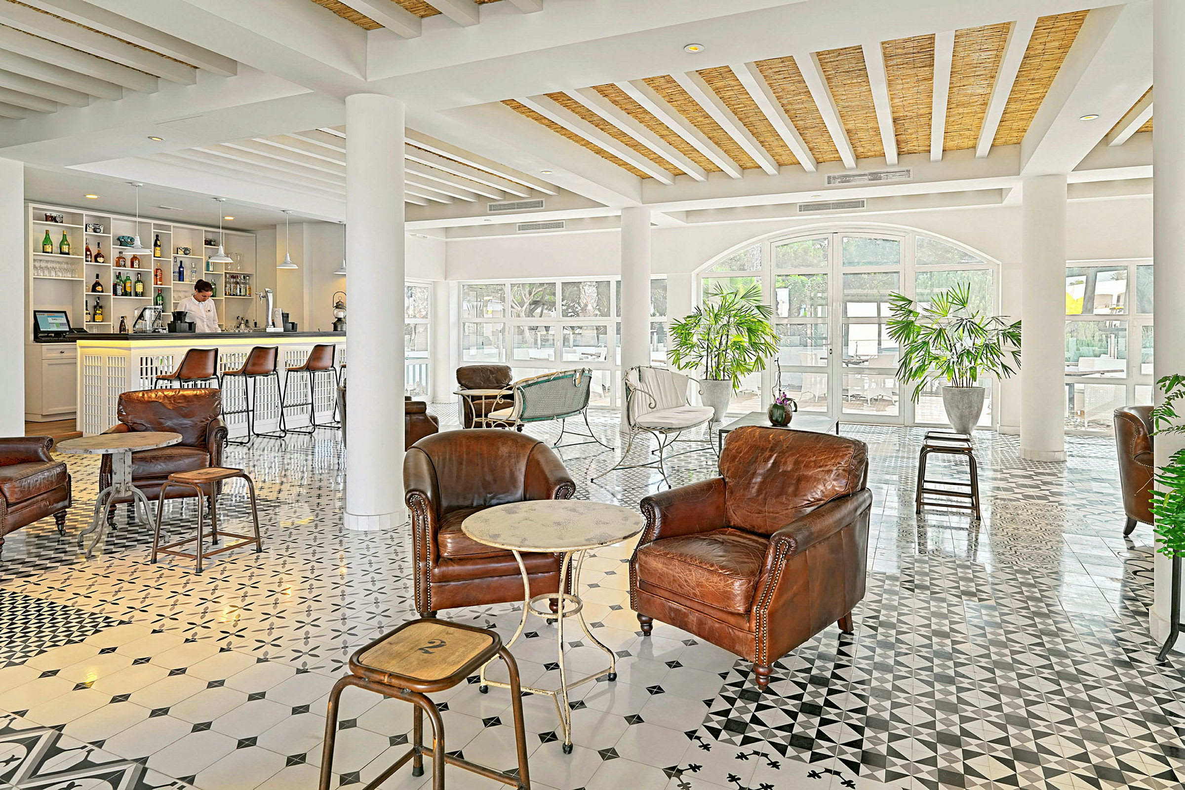 Ett elegant inrett loungeområde med skinnfåtöljer och ett kafé i bakgrunden. (AI-genererad text)